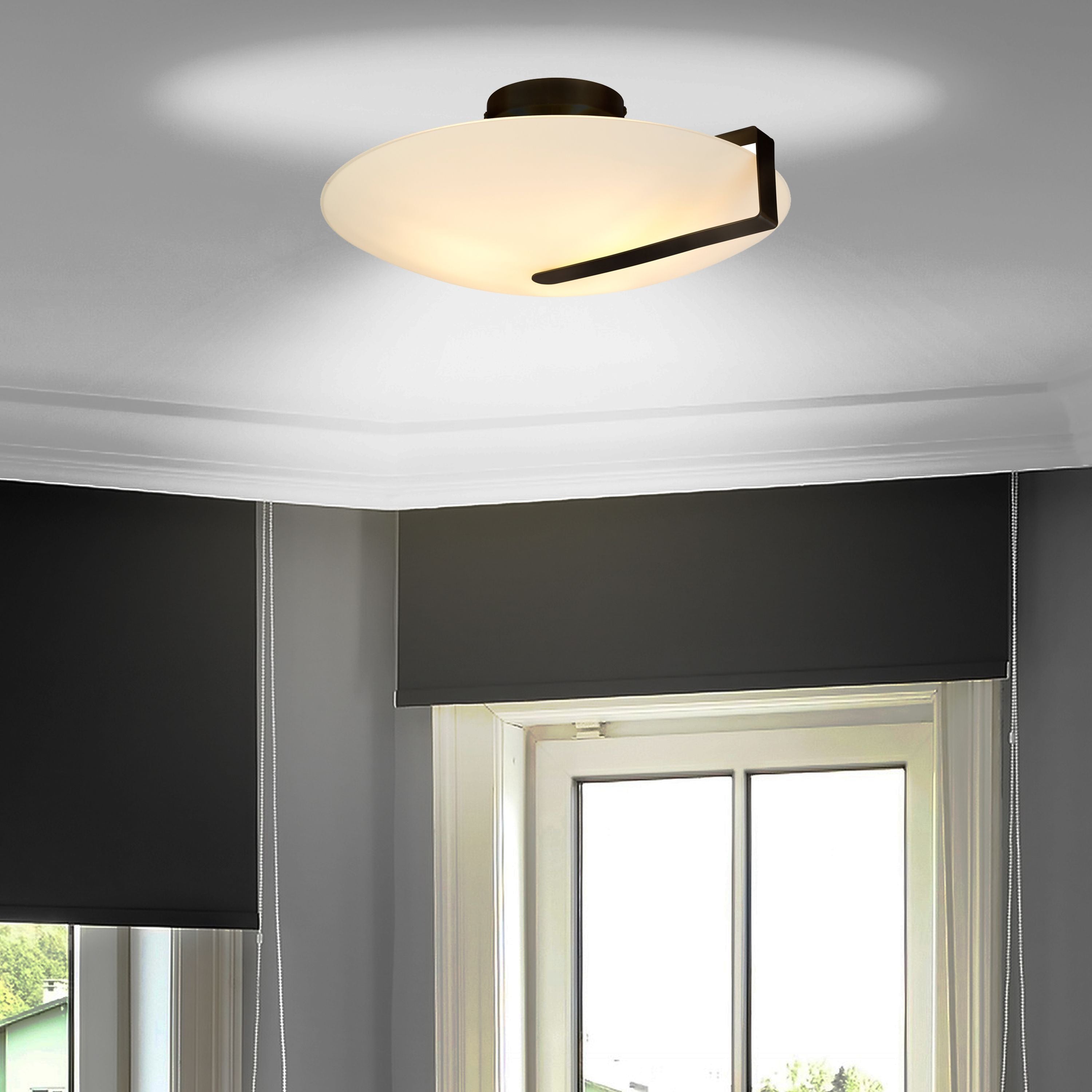 Searchlight Sundial flush ceiling light in black with frosted glass, styled on a room ceiling above a window with roller blinds