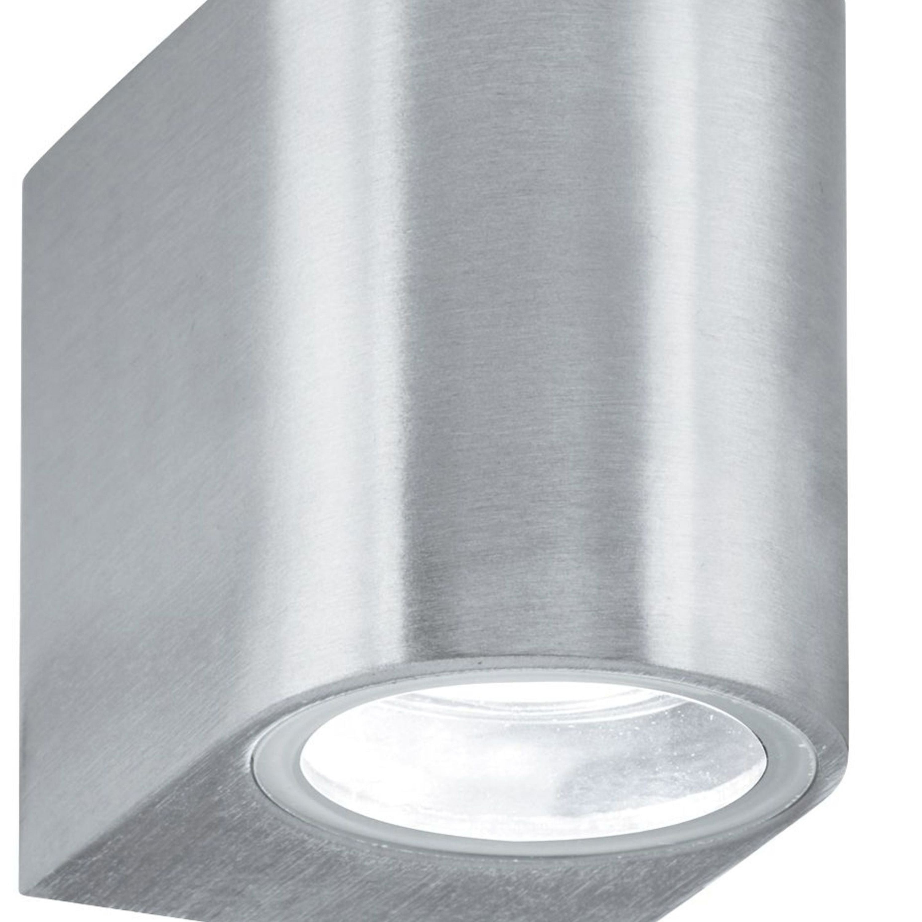 Close up of the Eiffel wall light's frosted glass lens glowing white against the brushed silver housing