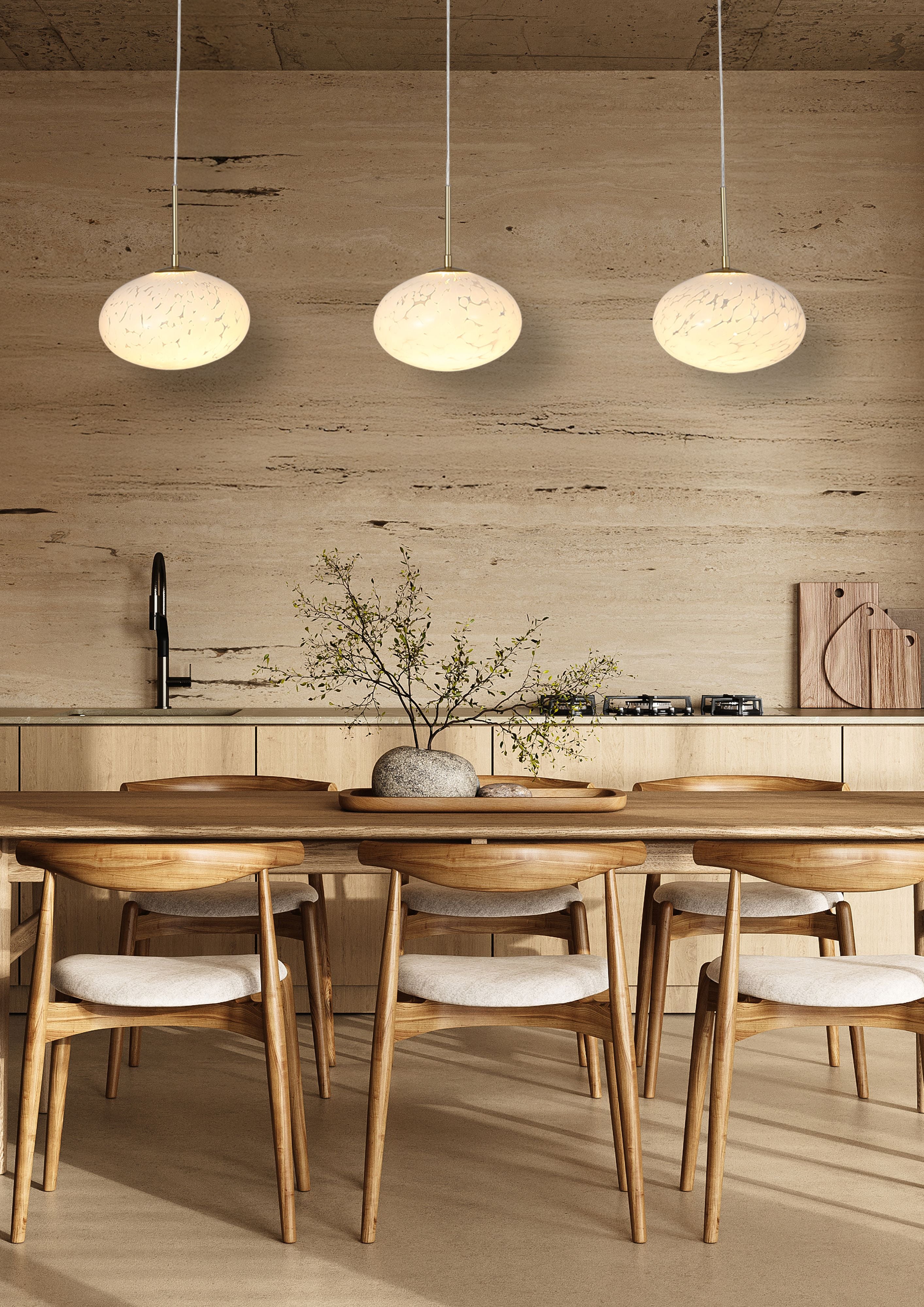 Three gold Searchlight Confetti LED Bar Pendant shades hanging above a dining table in a travertine walled kitchen