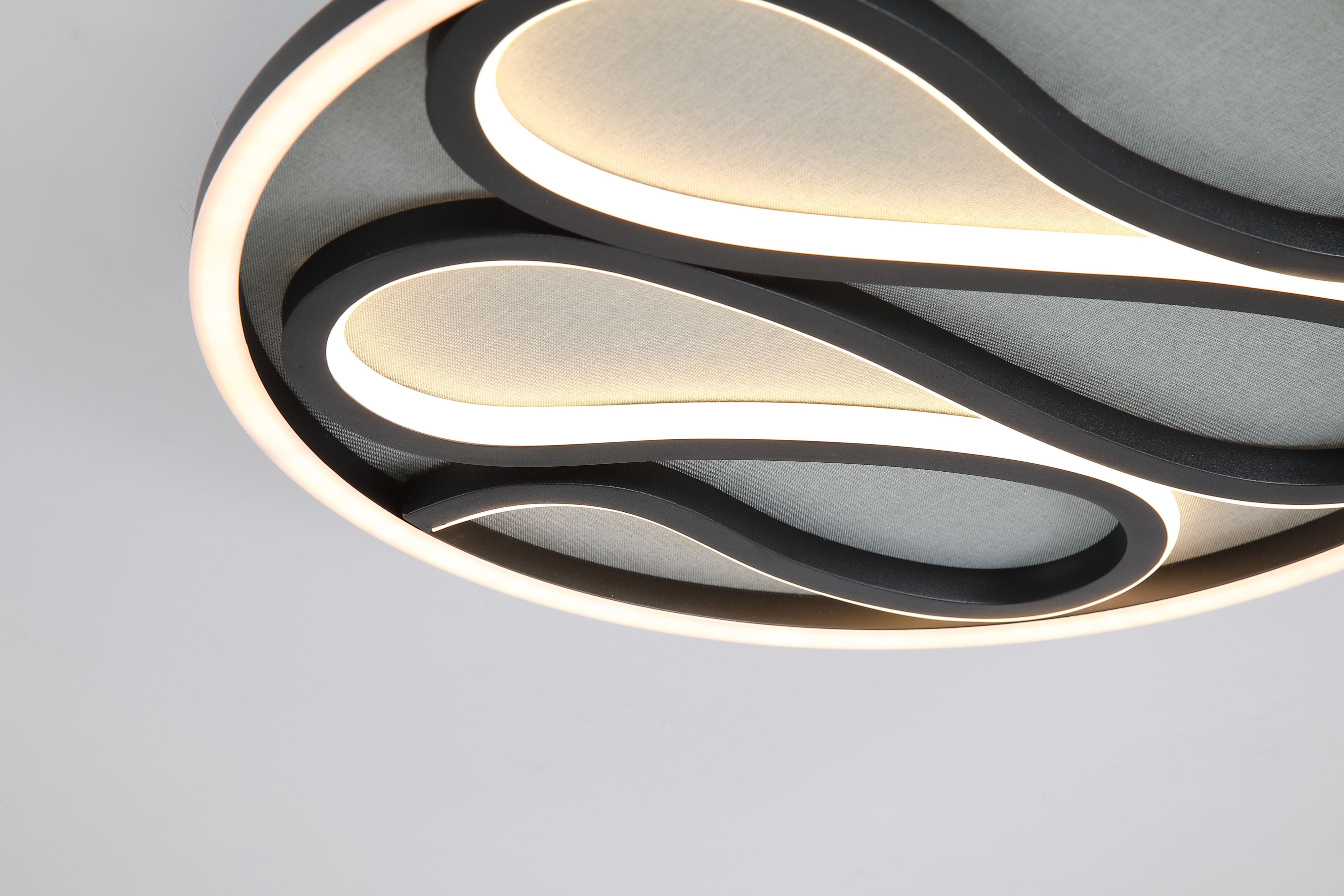 Close up of the Zendisc flush light fitted to a ceiling, showing the matt black frame and glowing silicone channels