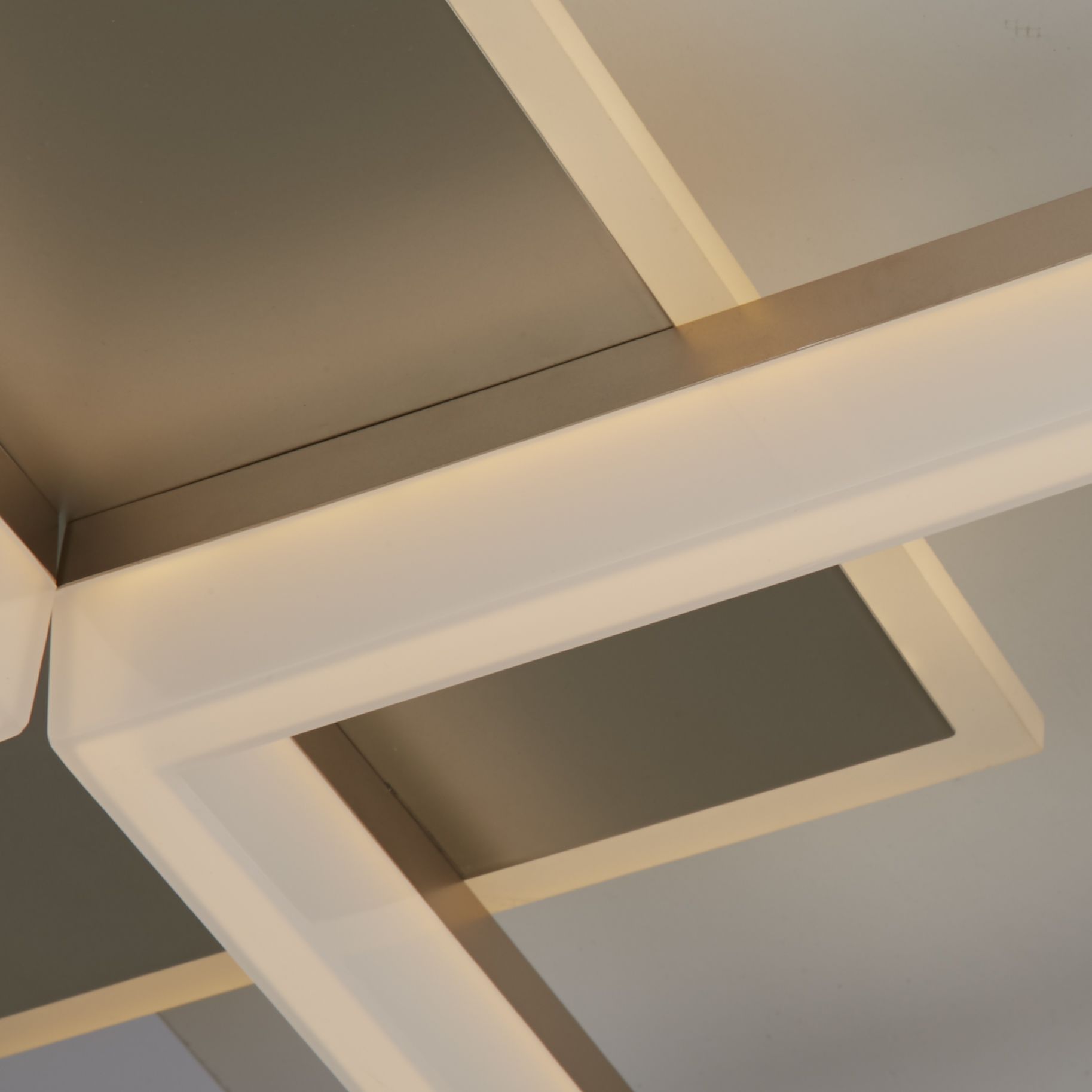 Close up of the Fence flush light's gold frame corner, showing the white acrylic diffuser strip glowing warm white