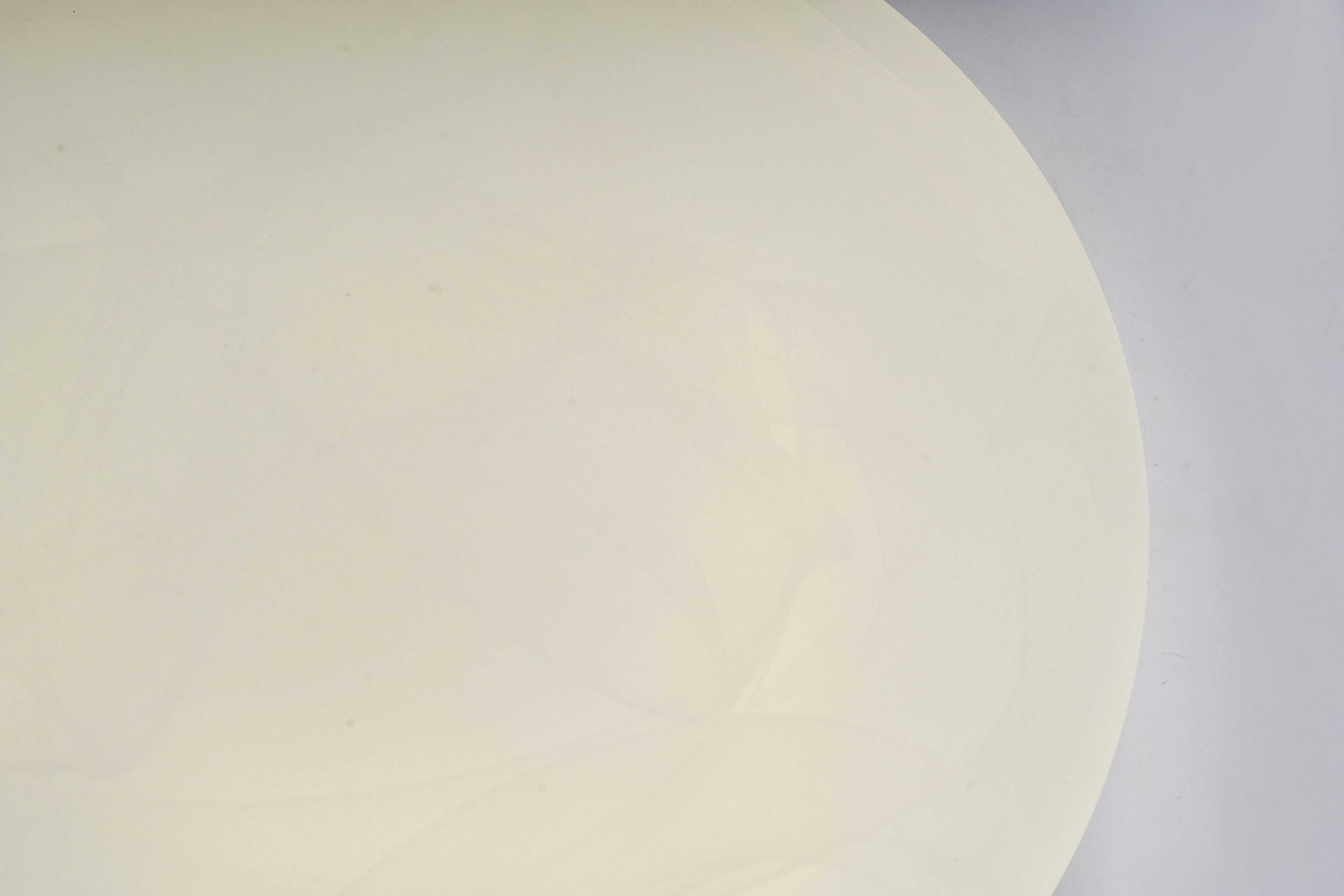 Close up of the white acrylic dome on the Searchlight Maya LED flush light showing the soft marbled swirl pattern