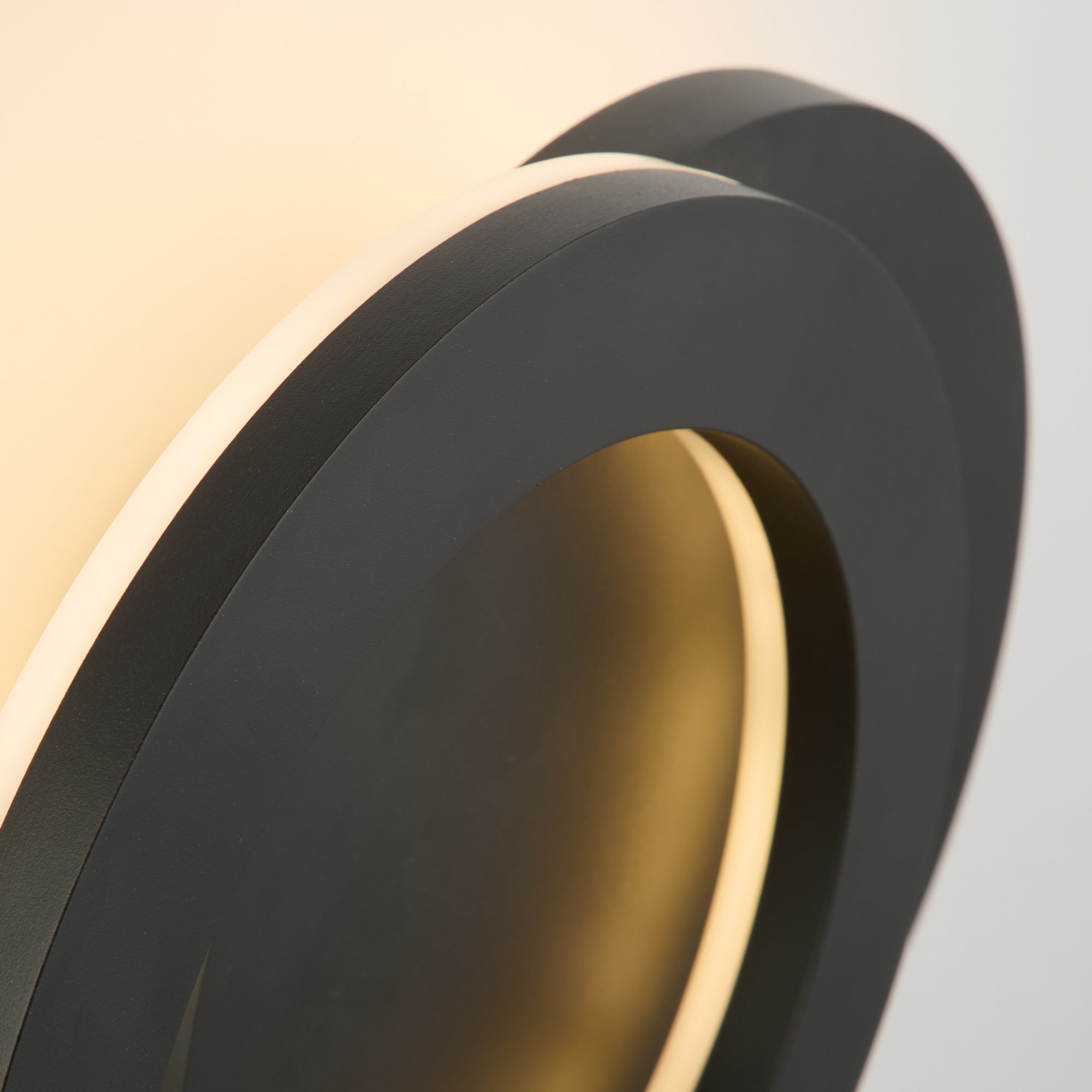 Close up of the Searchlight Hyde LED outdoor wall light showing the front disc rotated open and the warm white light glowing from the ring behind it