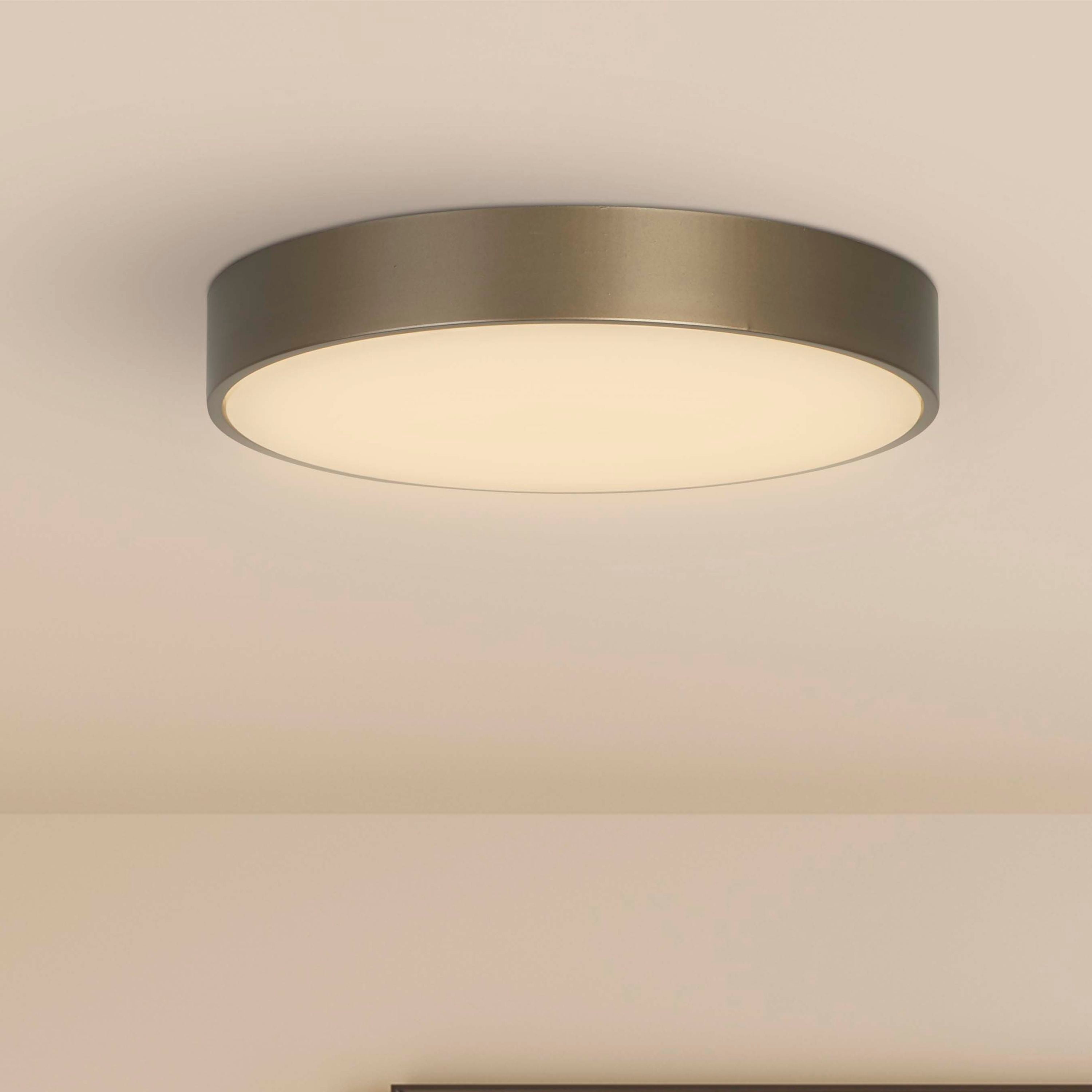 Searchlight Palma LED flush ceiling light installed on a ceiling above a framed abstract print in a pink toned room