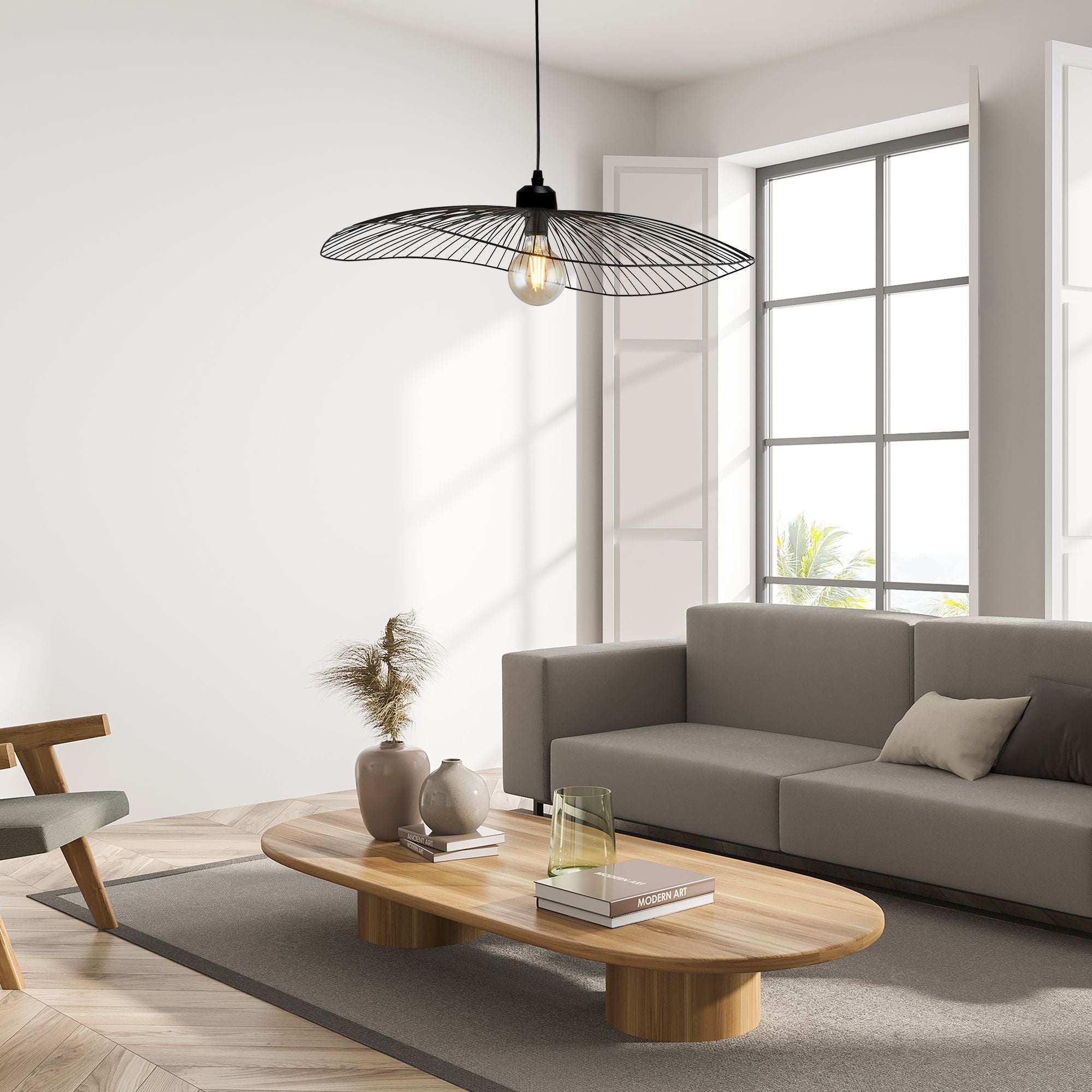 Searchlight Wave pendant in matt black hung above a coffee table in a modern living room setting