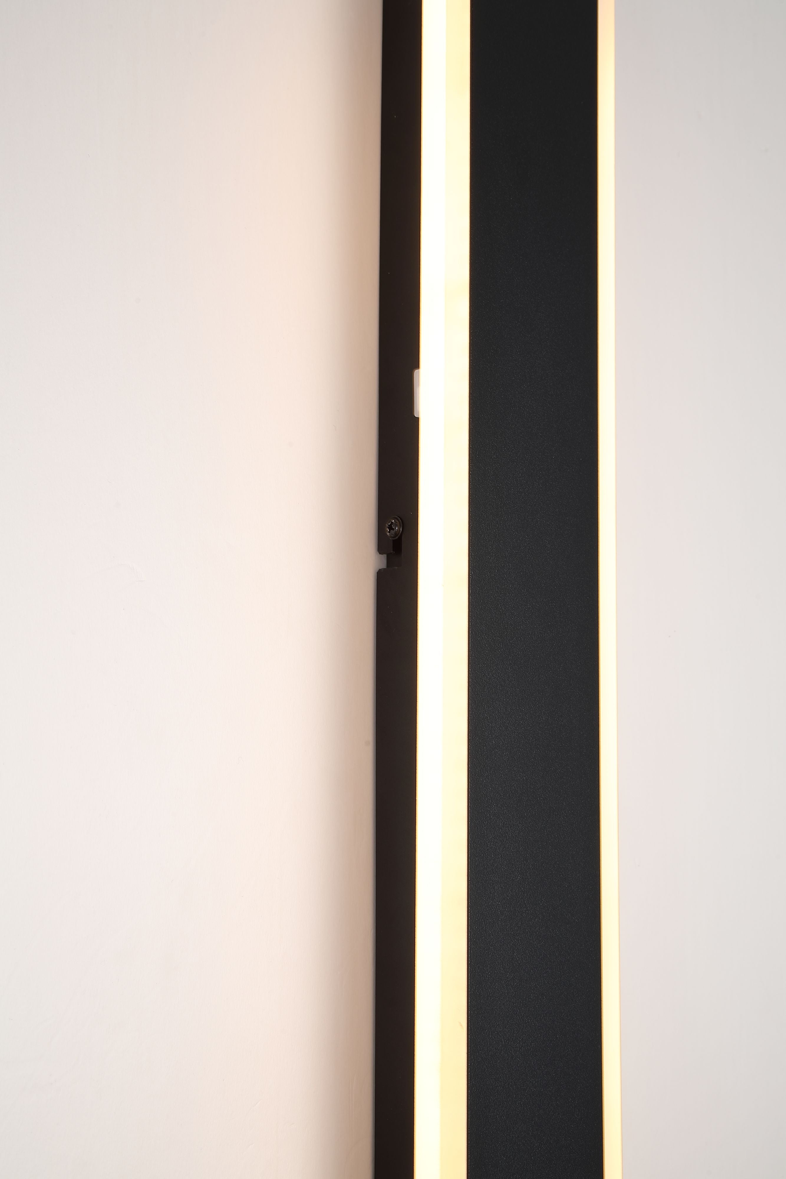 Close up view of the Bordo II Square wall light installed and lit, showing the side profile, mounting screw and slide switch