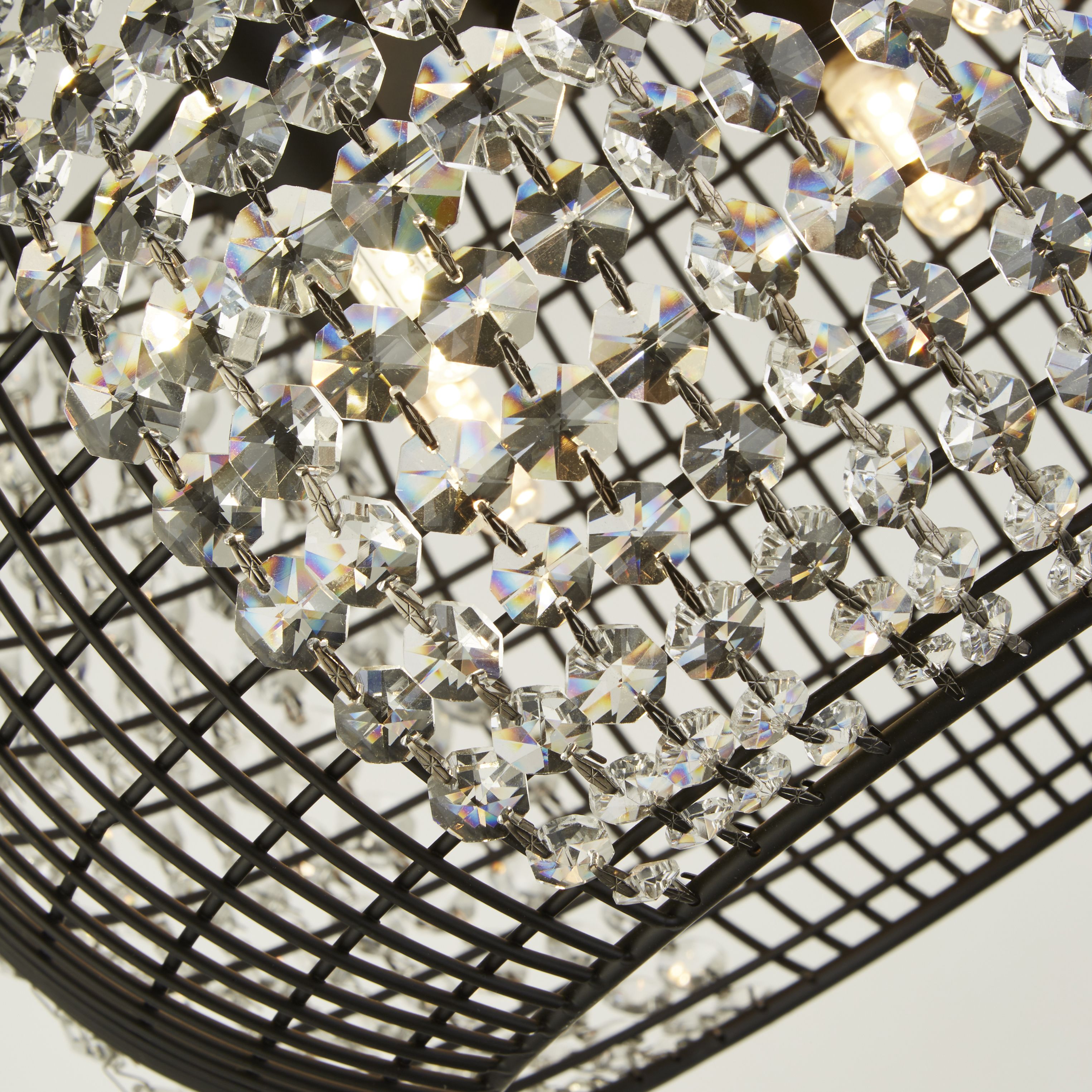 Close up of the Cage pendant showing the faceted crystal glass octagons filling the black wire grid shade, with bulbs lit inside