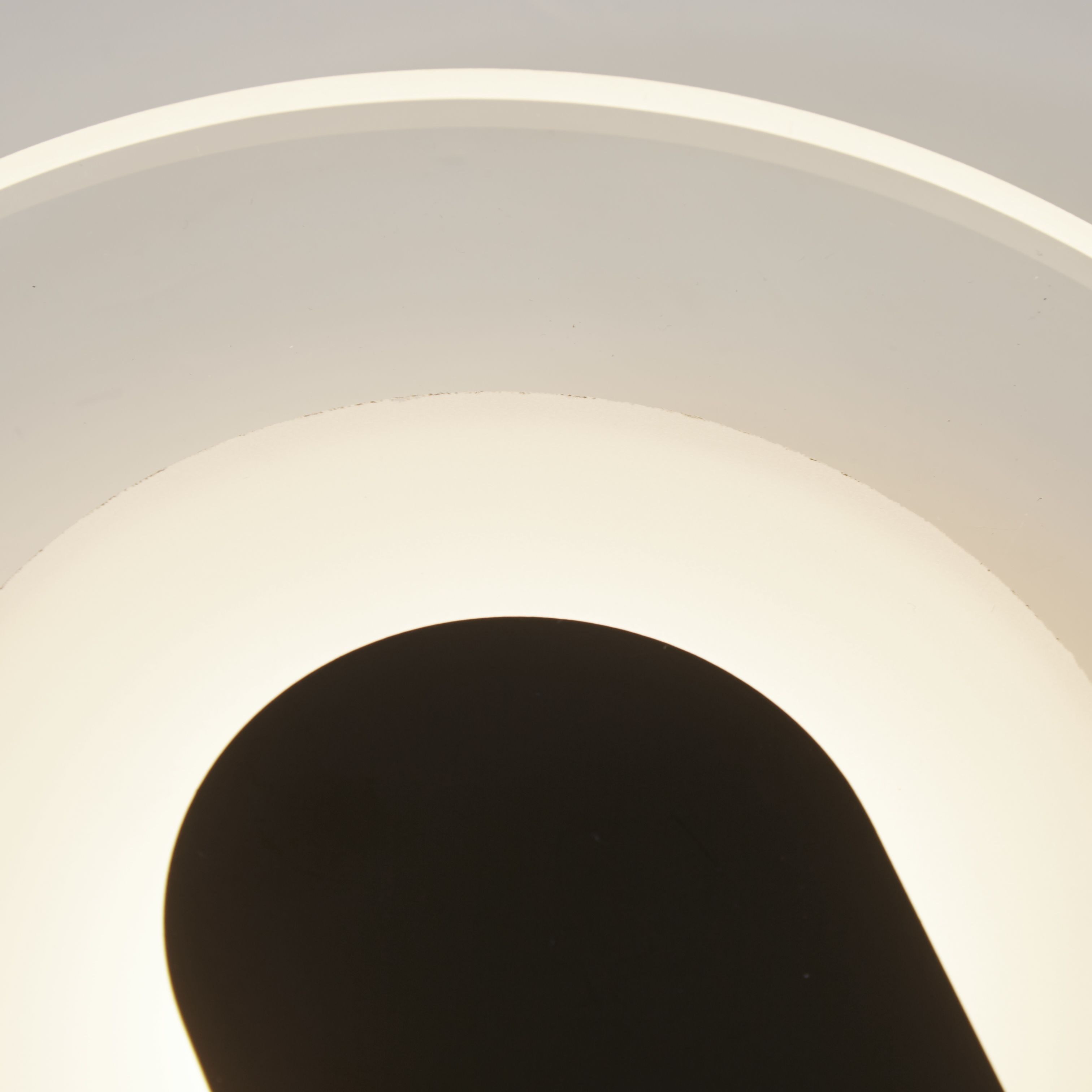 Close up of the Target wall light's frosted acrylic diffuser and sand black arch bracket, showing the lit halo around the arch