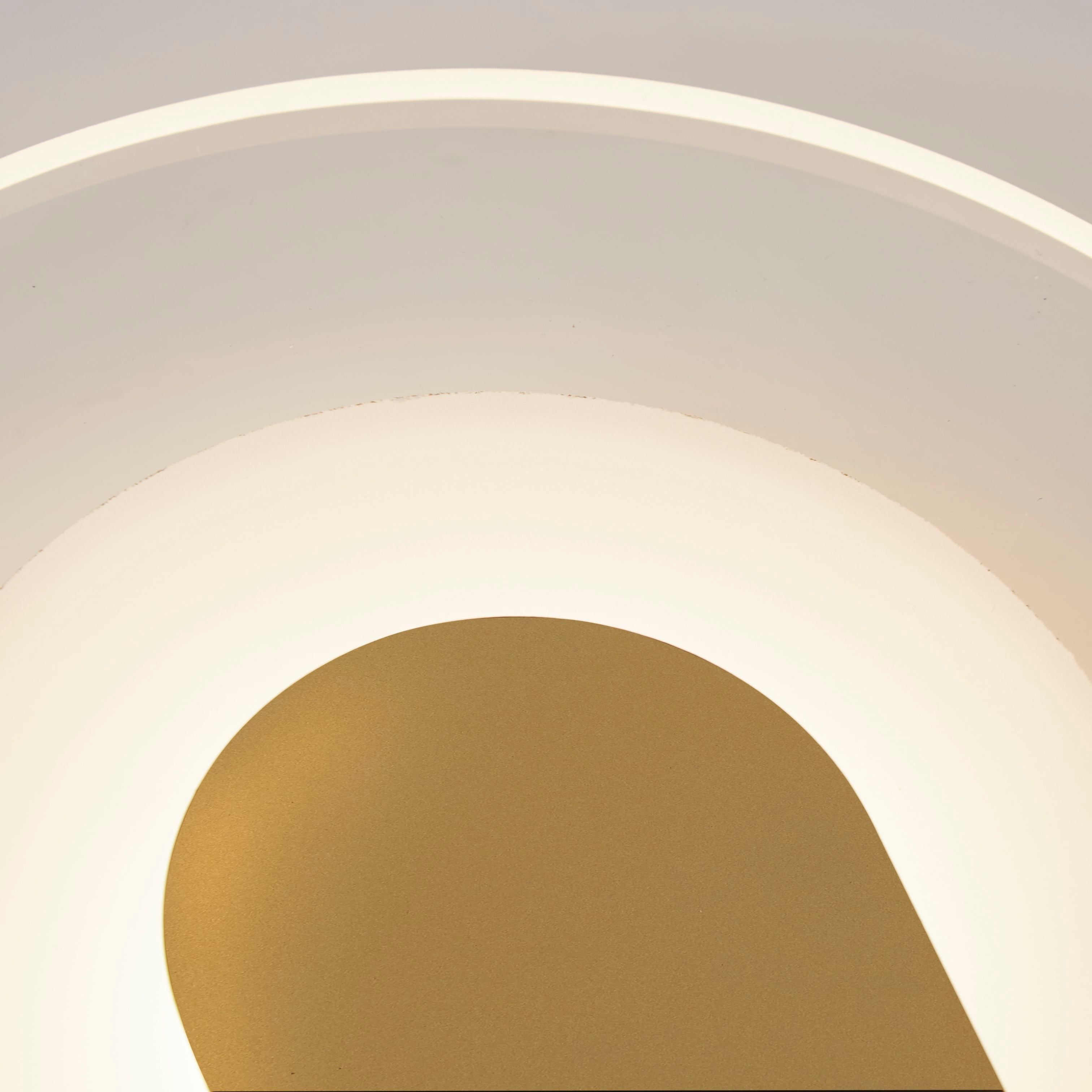 Close up of the Target wall light's frosted acrylic diffuser and sand gold arch bracket, showing the lit halo around the arch