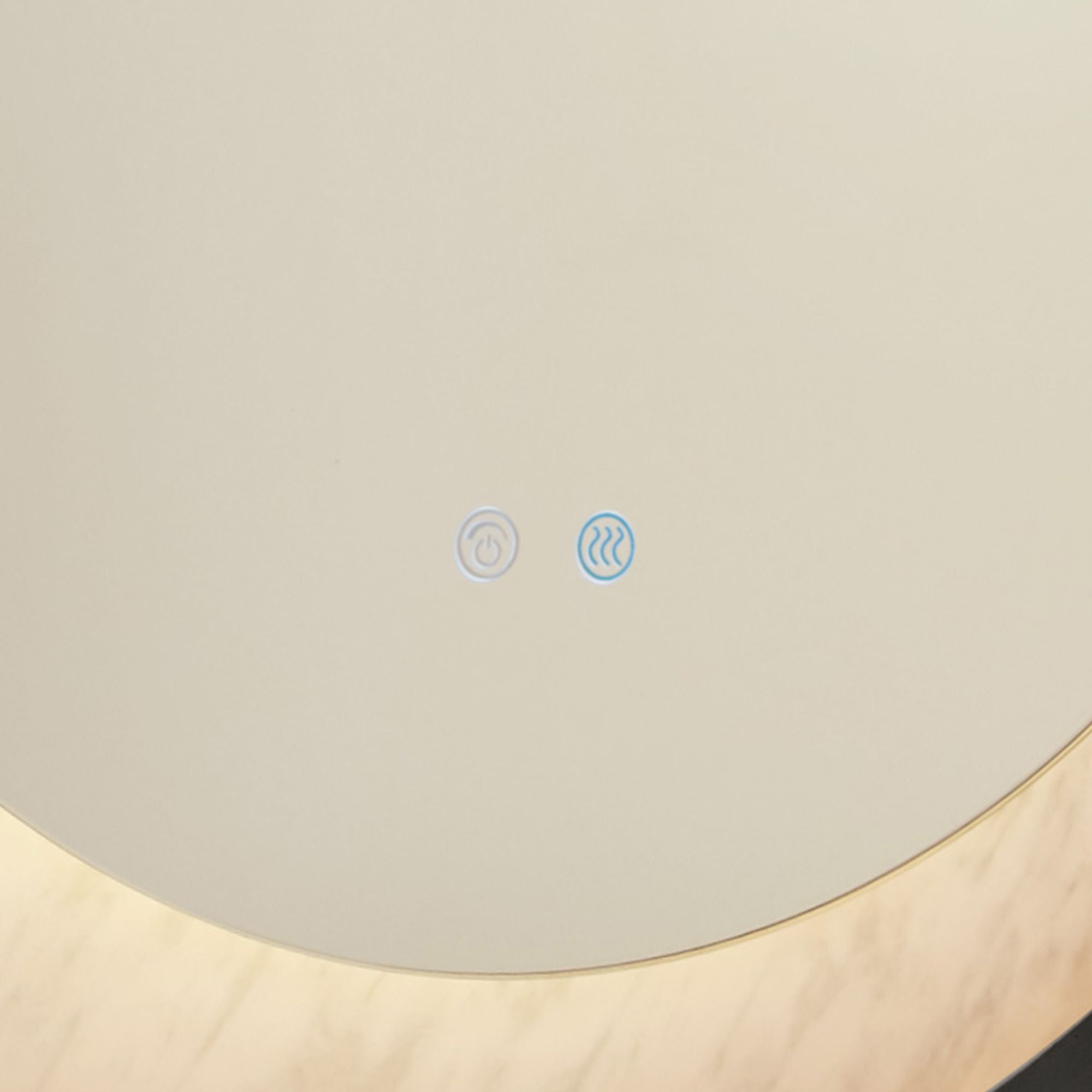 Close up of the touch power and demister control icons on the Searchlight Luxo mirror, with the marble effect ring glowing warm amber in the corner