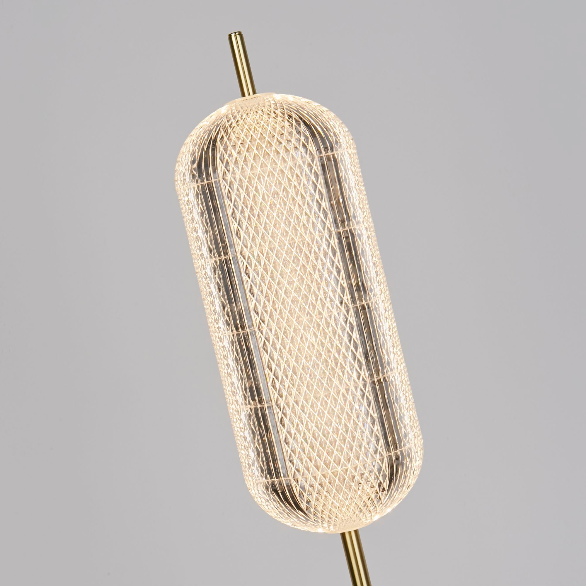 Close up angled view of the Capsule floor lamp's faceted acrylic shade, showing the diamond lattice texture lit from within