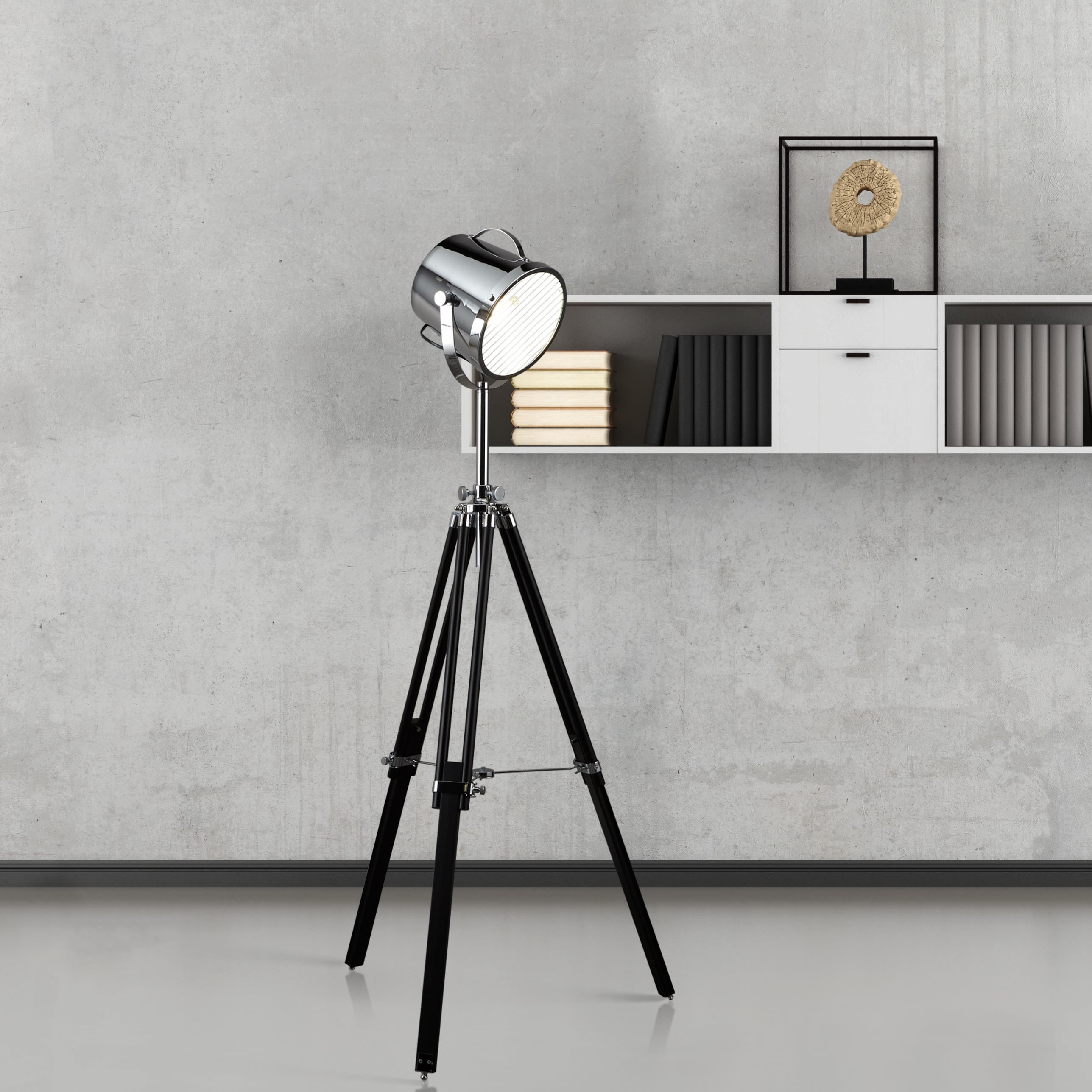 Searchlight Studio Adjustable Floor Lamp on its tripod base beside a shelving unit with books and a display piece