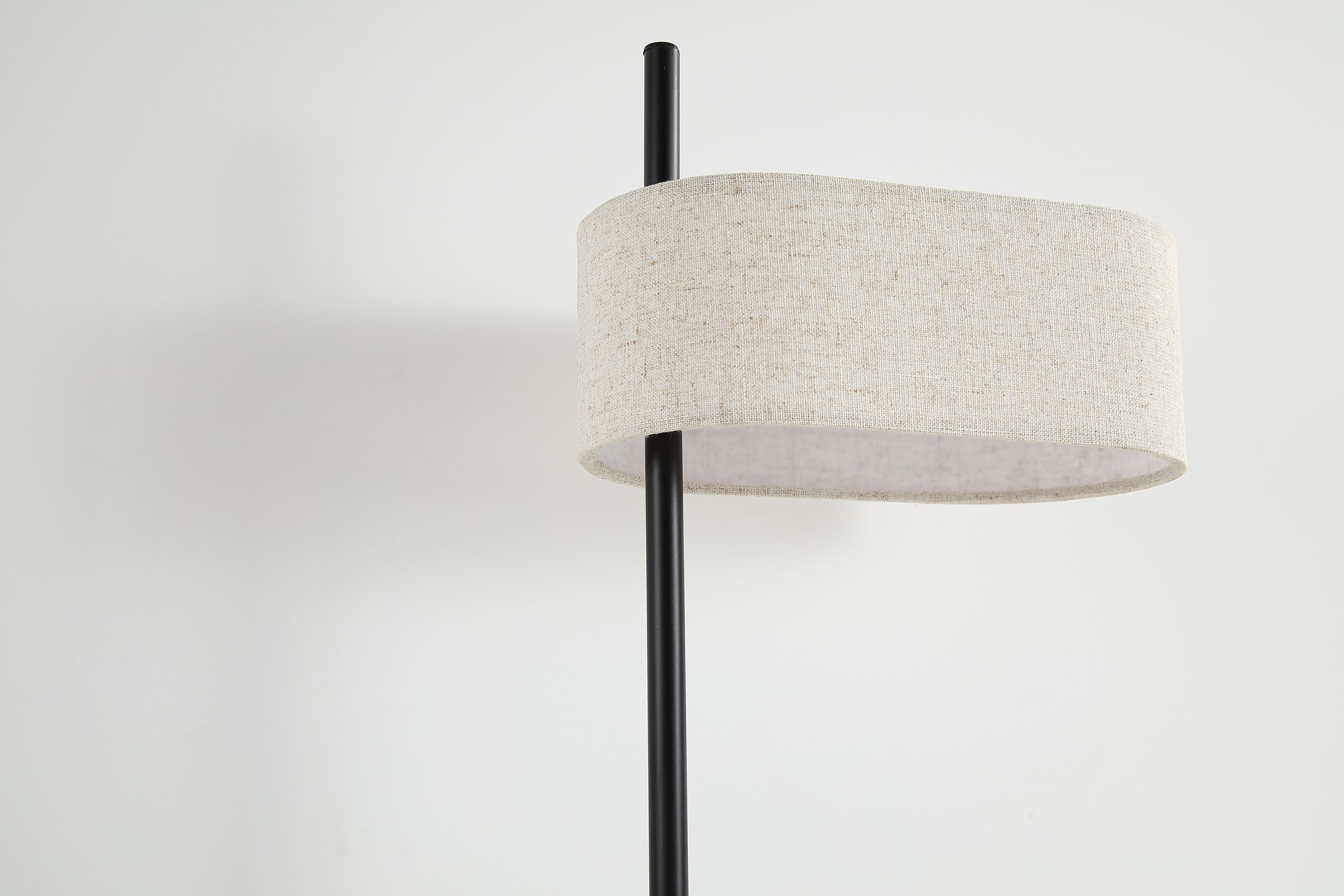 Close up of the Searchlight Hessian lamp shade showing the woven texture of the natural linen and the black metal stem passing through it
