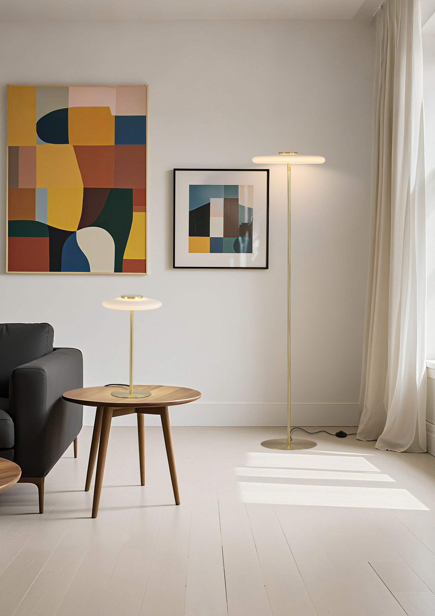 Gold Record table lamp and matching floor lamp switched on and styled in a living room with framed artwork