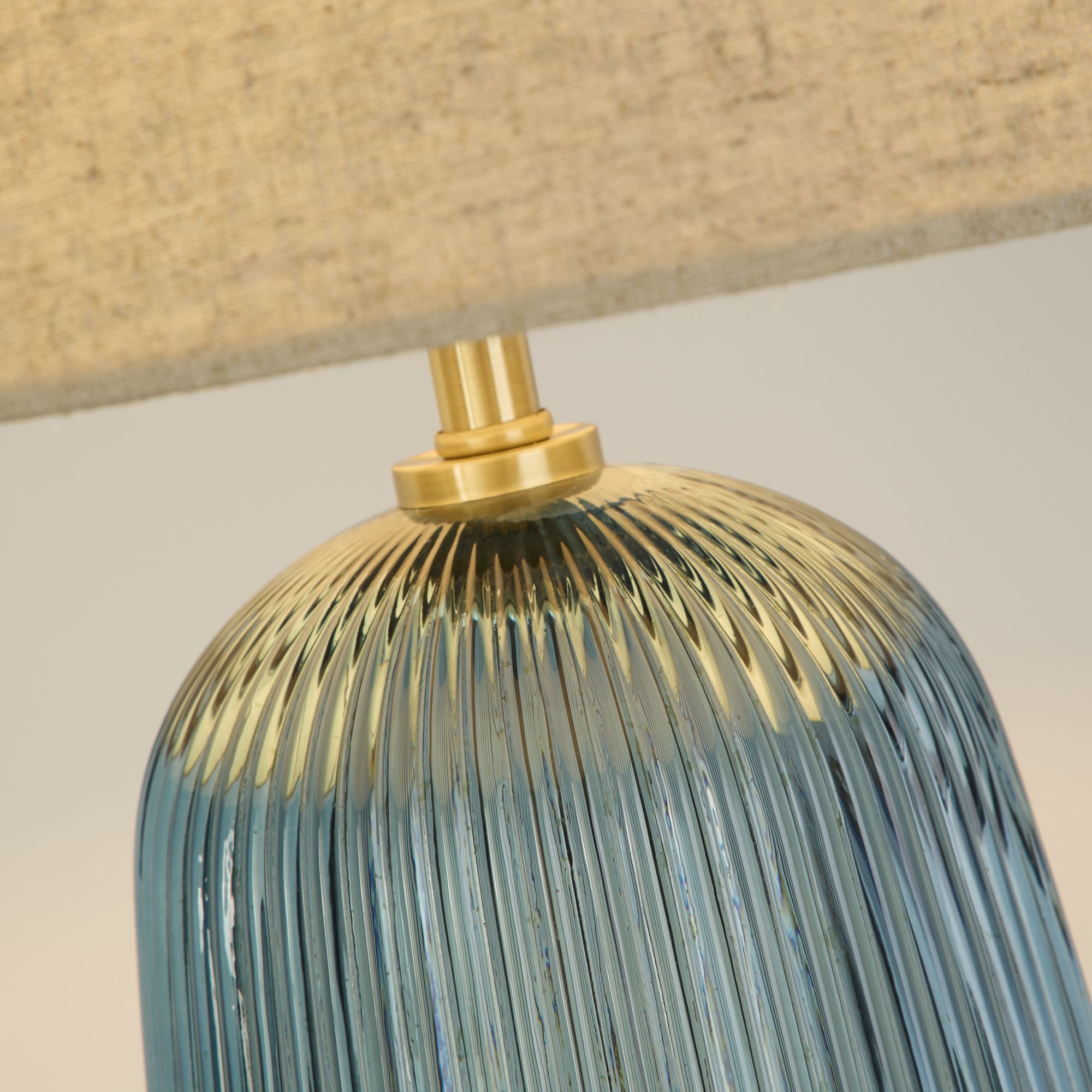 Close up of the brass coloured neck fitting and ribbed blue glass on the Cameo table lamp base