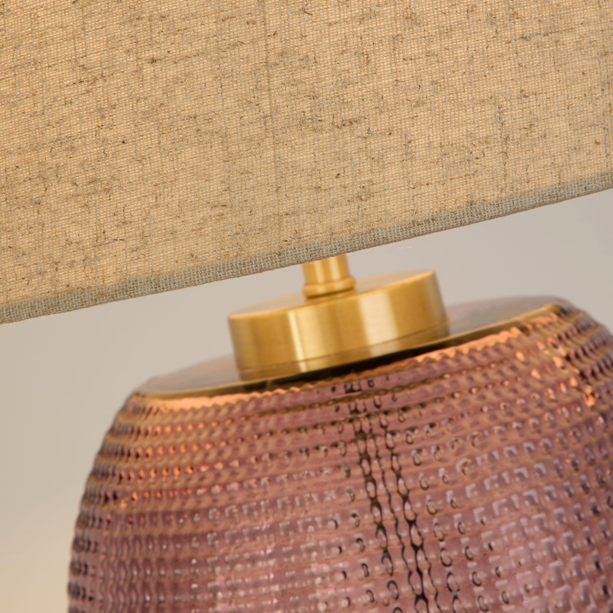 Close up of the brass coloured neck fitting and dimpled pink glass texture on the Amethyst table lamp base