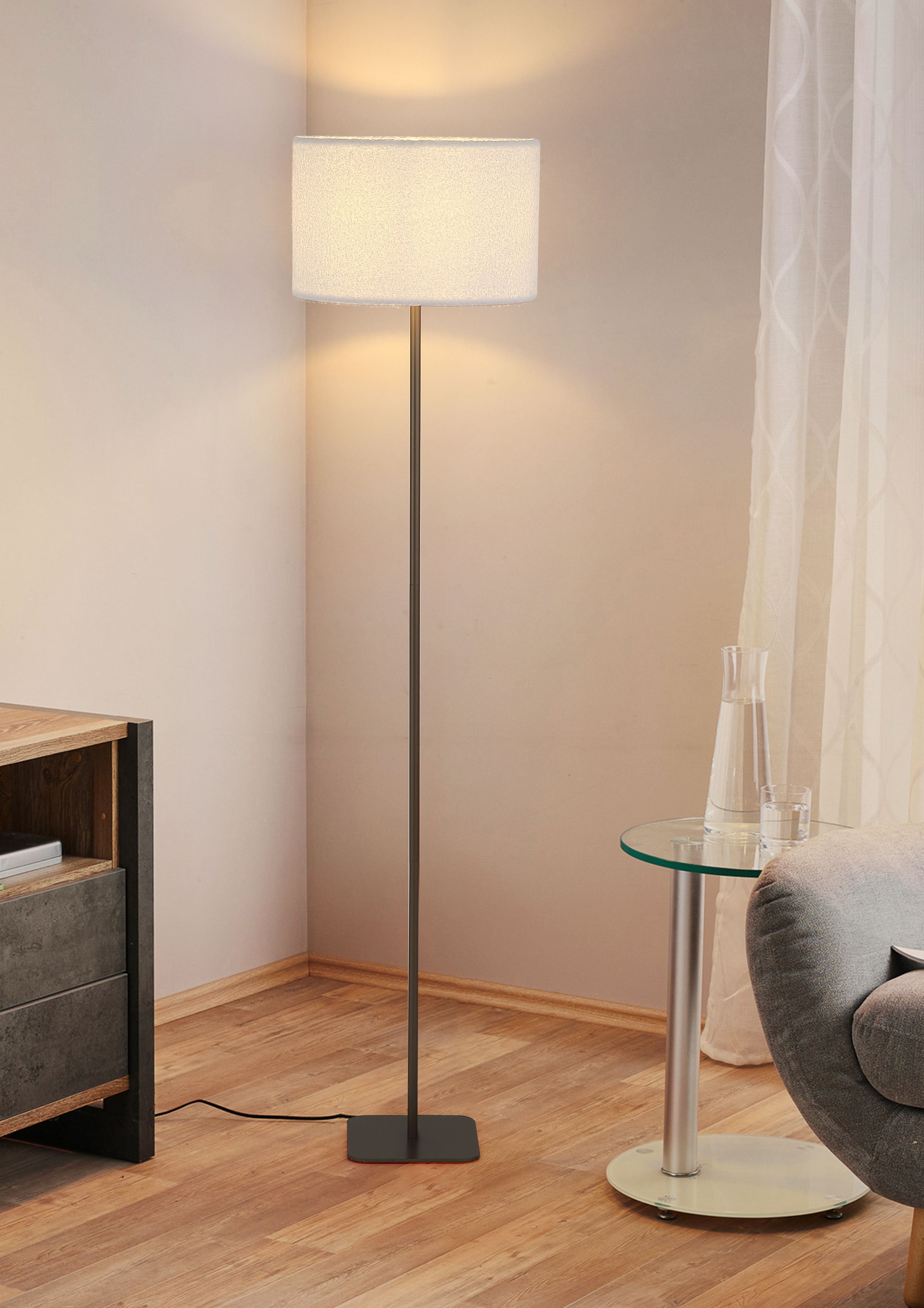 Chelsea floor lamp styled in a living room corner, lit beside a grey armchair and glass side table