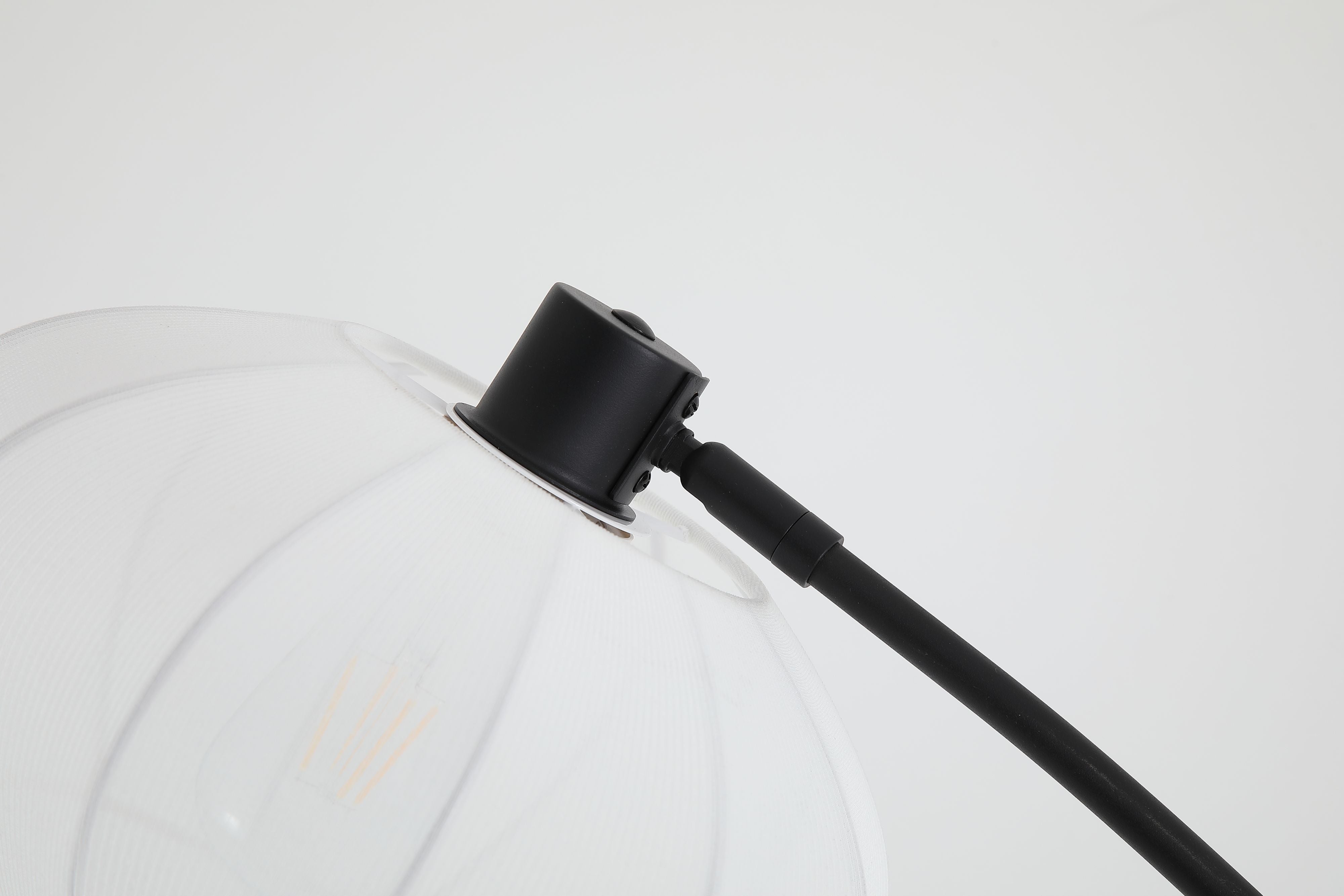 Close up of the Radiant floor lamp's bud shaped shade and black gimbal joint at the top of the curved arm