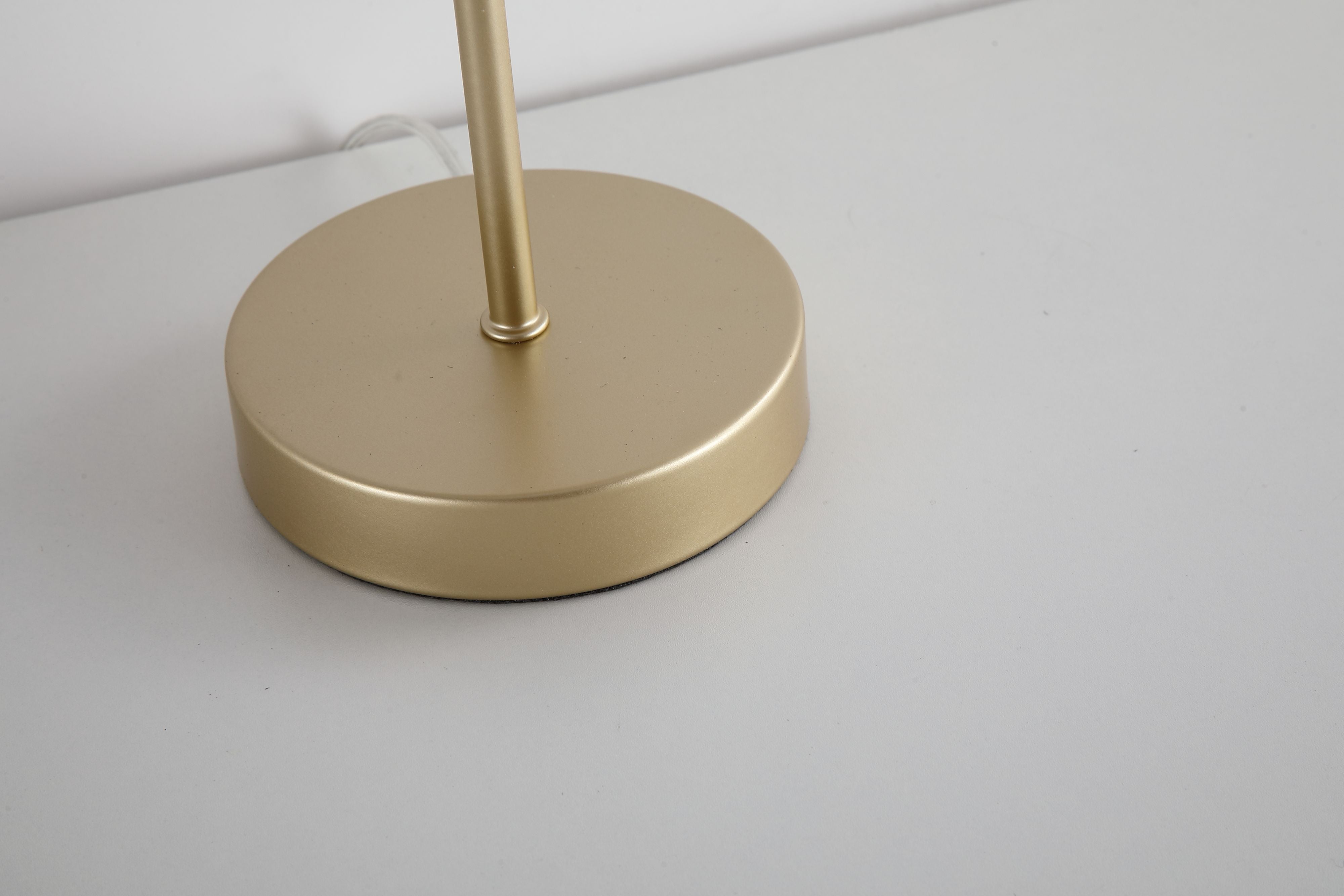 Close up of the Swizzle gold table lamp base and stem showing the brushed gold finish