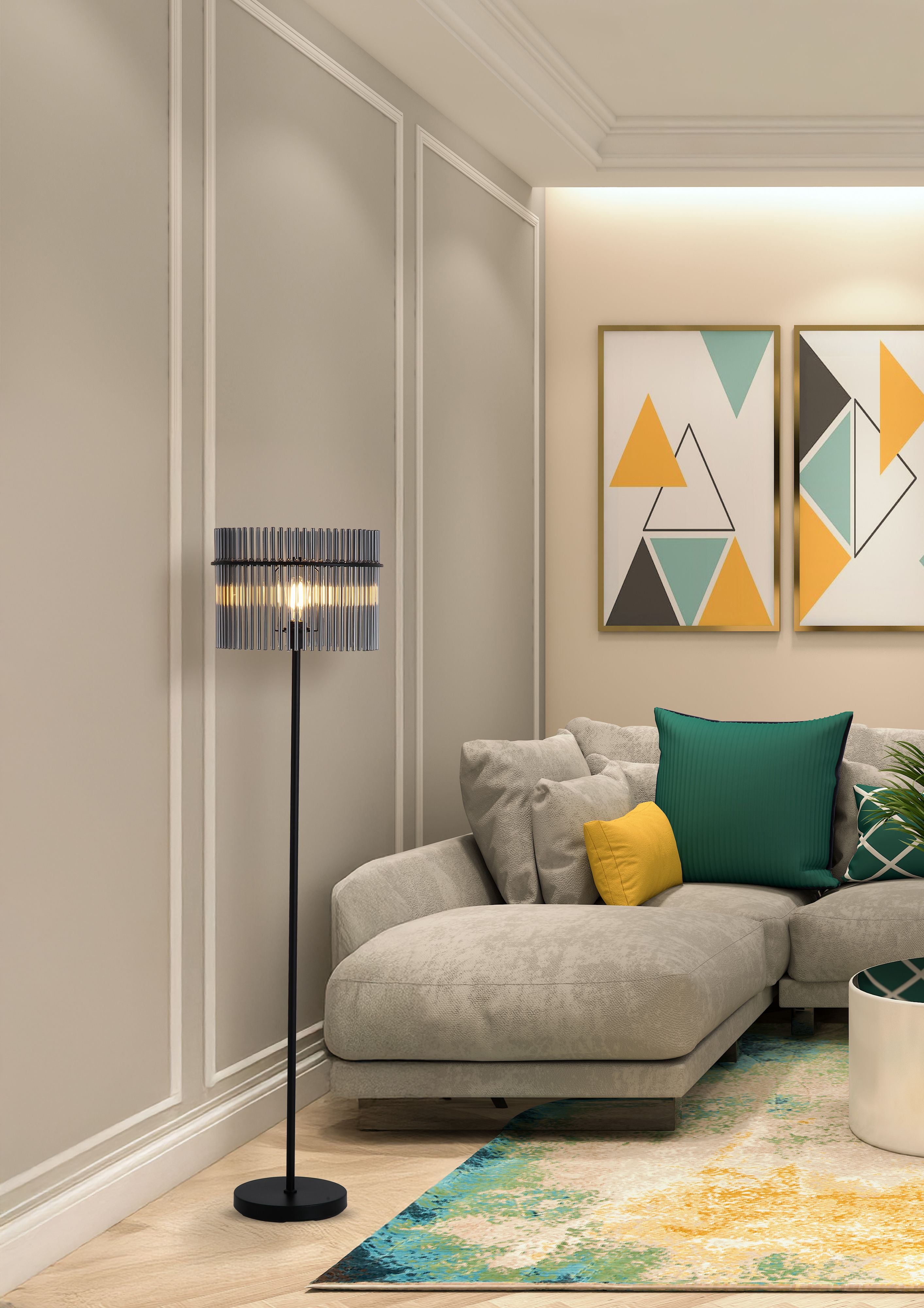 Swizzle floor lamp in matt black styled in a living room corner next to a beige sofa with green and yellow cushions