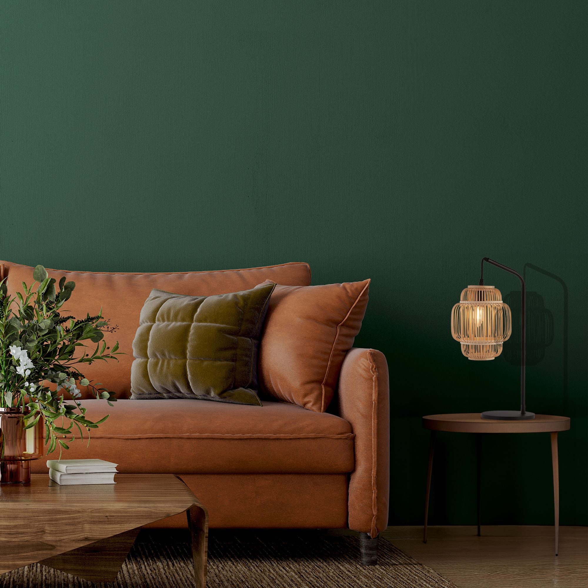 Java table lamp styled on a dark green wall beside a tan leather sofa