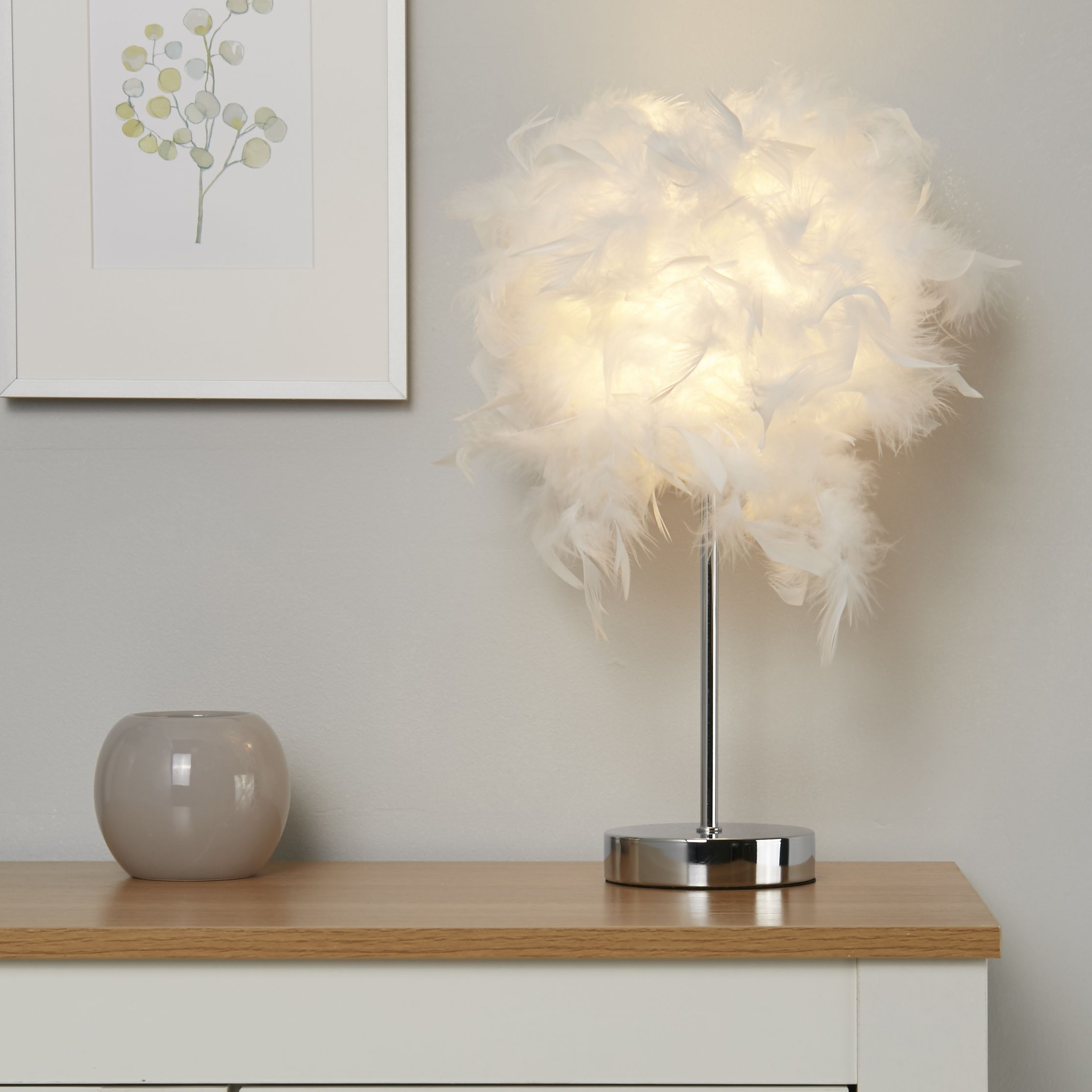 Hattie table lamp lit and styled on a white console table beside a botanical print and small vase