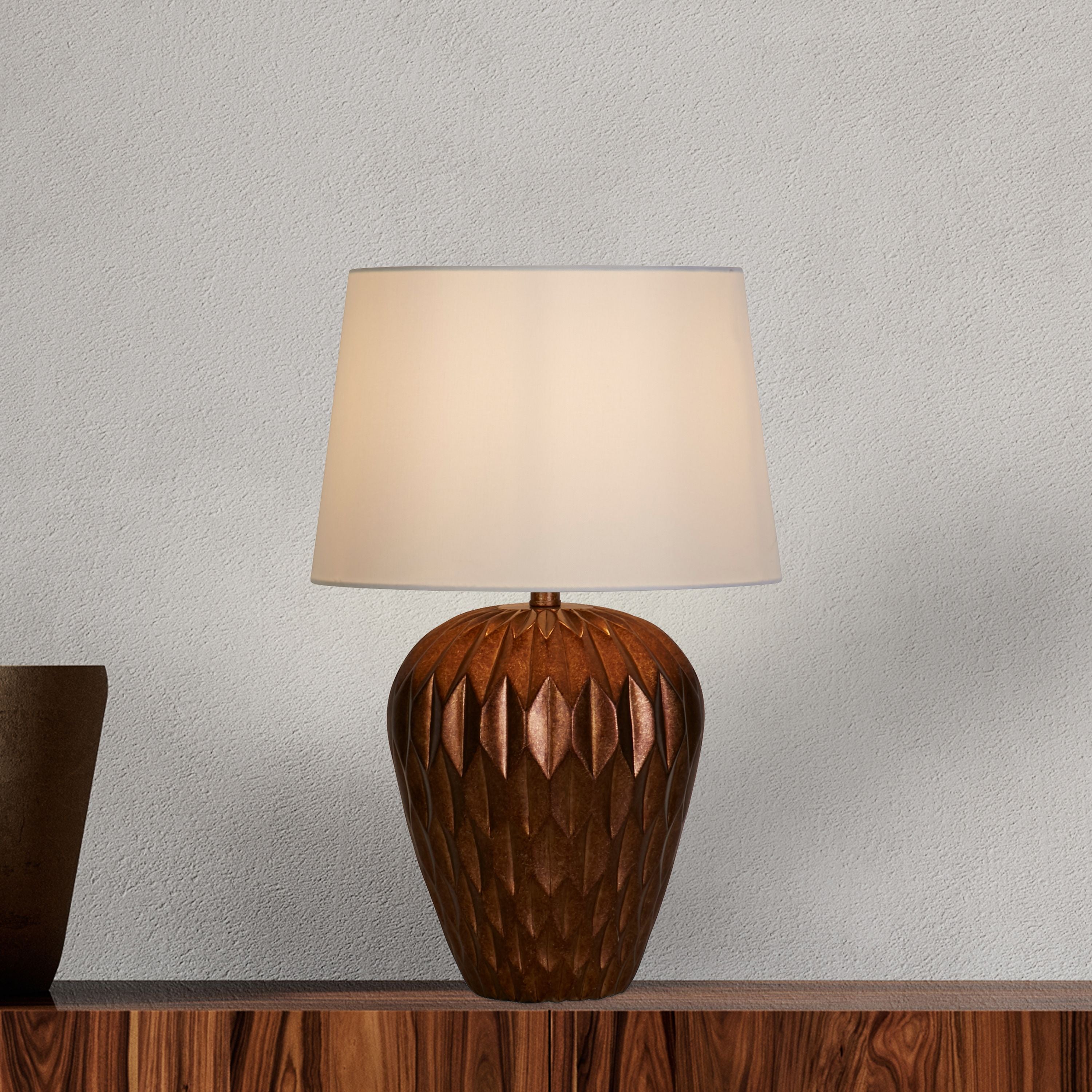 Rosetta table lamp styled on a wooden sideboard against a textured plaster wall