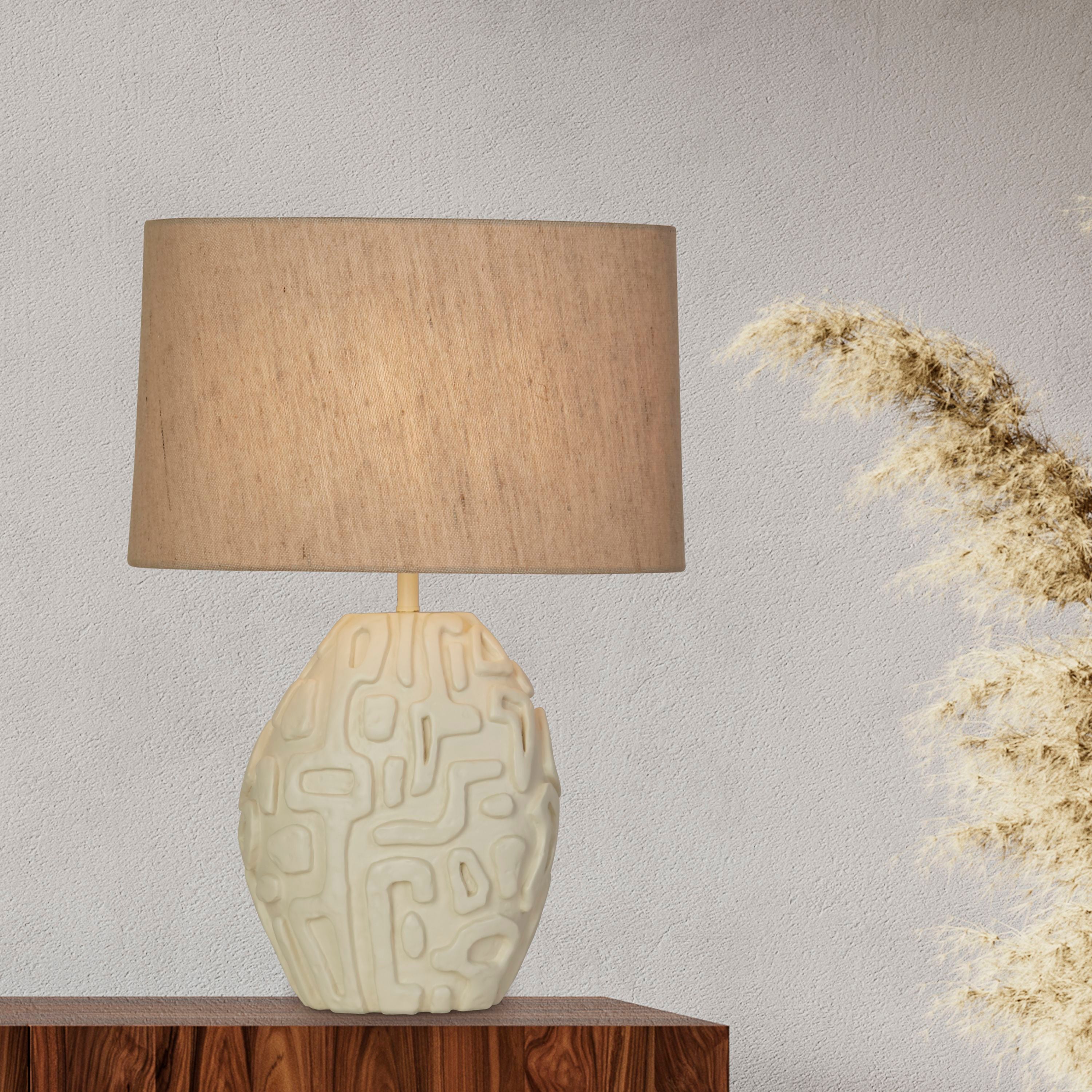 Searchlight Adelaide table lamp lit on a dark wood sideboard beside a dried pampas grass stem, against a plain white textured wall