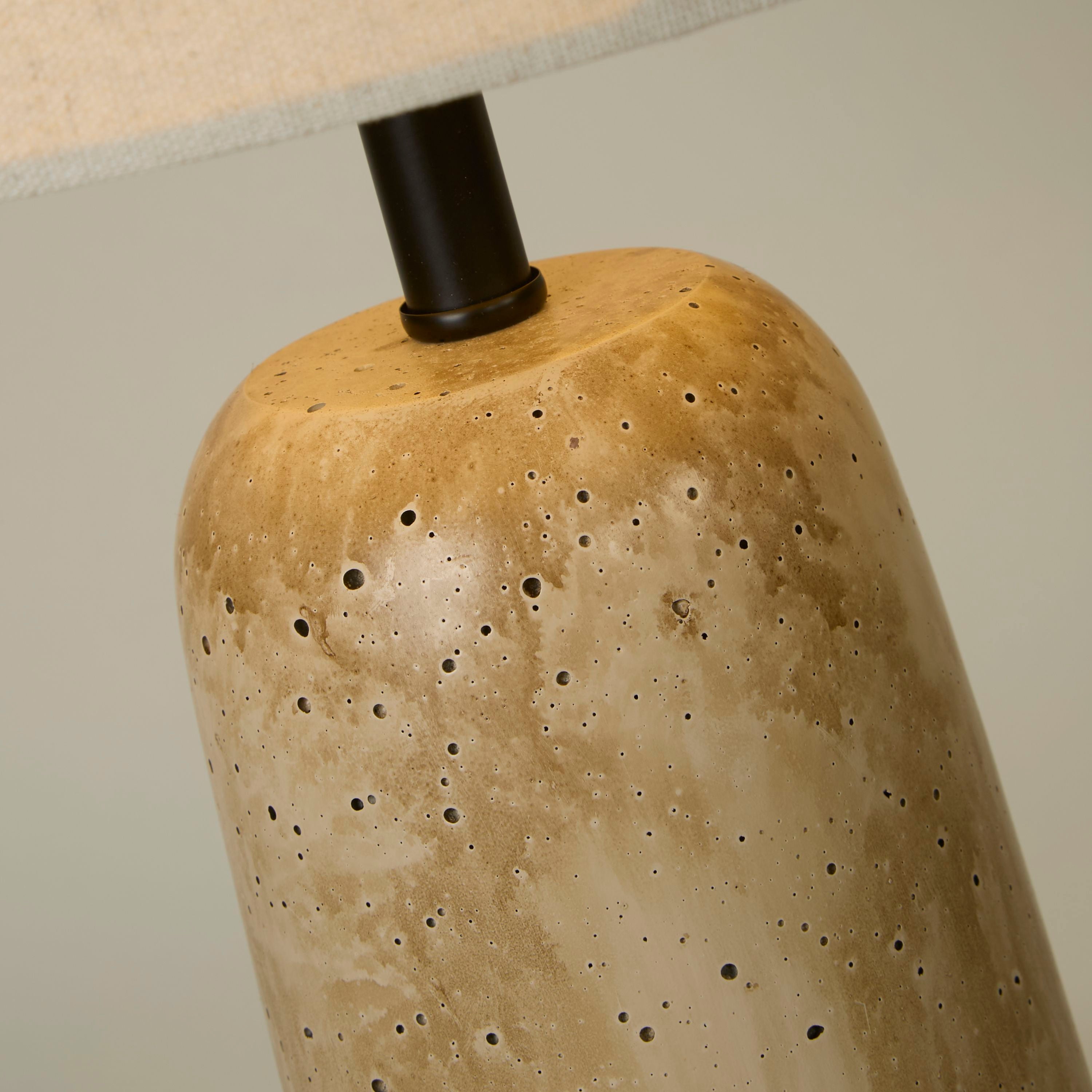 Close up of the Agra table lamp base showing the pitted, travertine effect glaze texture