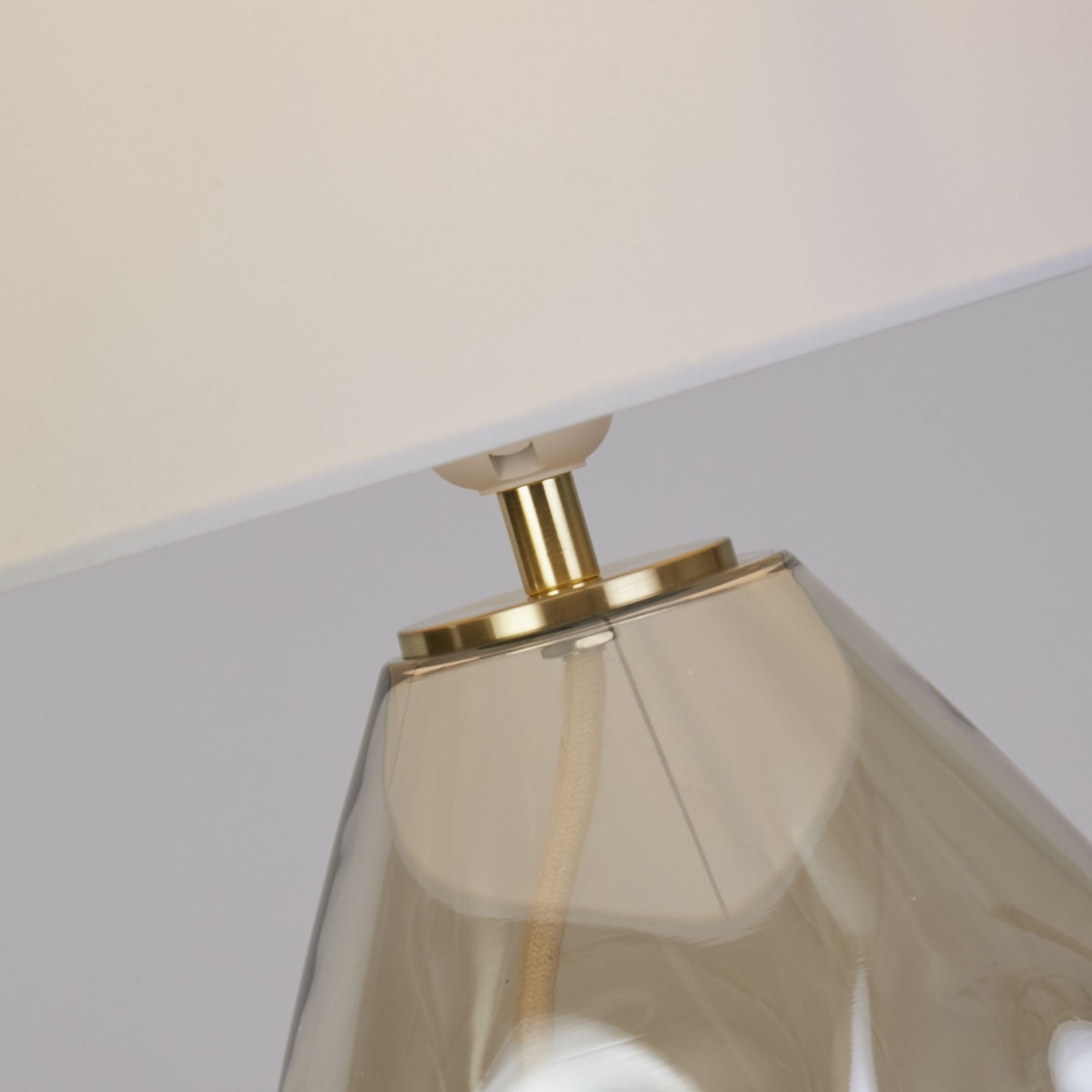 Close up of the Devon champagne table lamp brass coloured neck collar and dimpled glass texture