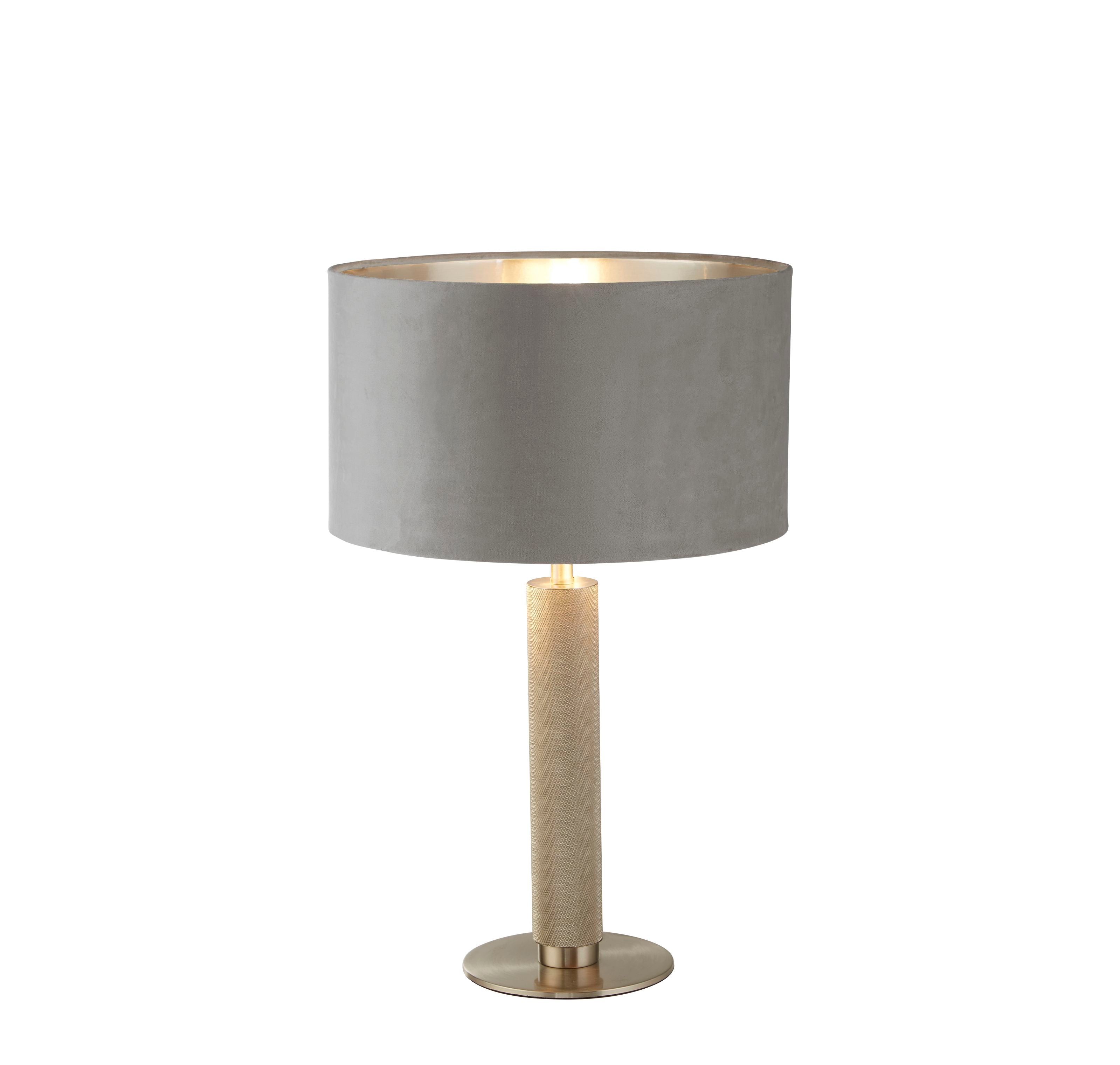 Searchlight London table lamp with a knurled brass toned metal column and a grey velvet drum shade with a reflective gold lining, photographed lit on a plain white background