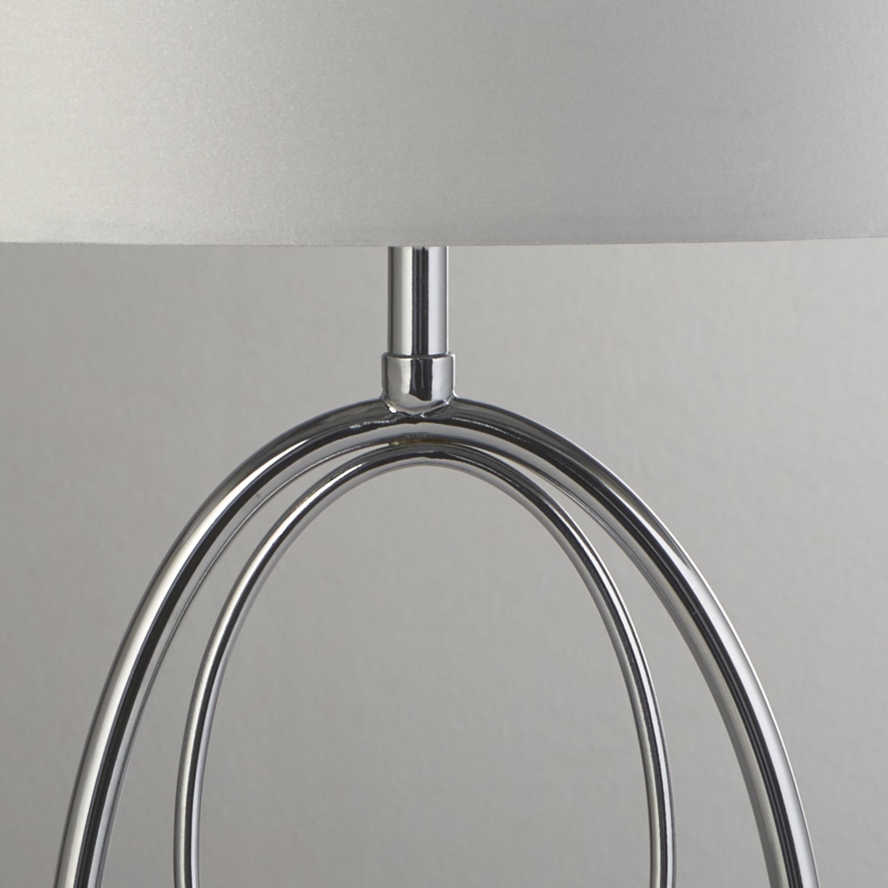 Close up of the Loopy lamp's chrome interlocking oval rings where they meet the shade neck