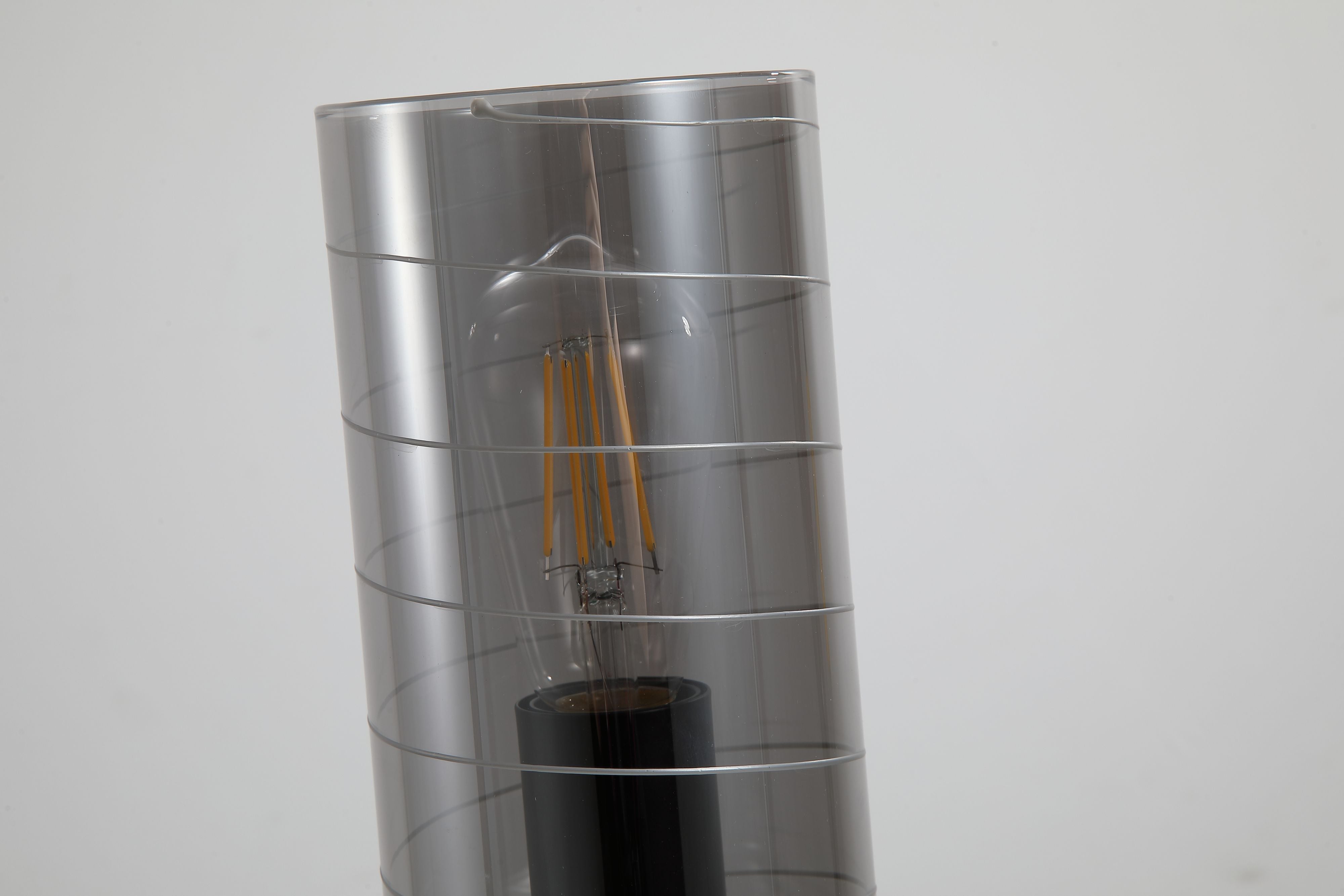 Close up of the exposed filament bulb and spiral line pattern on the smoked glass of the Broughton table lamp