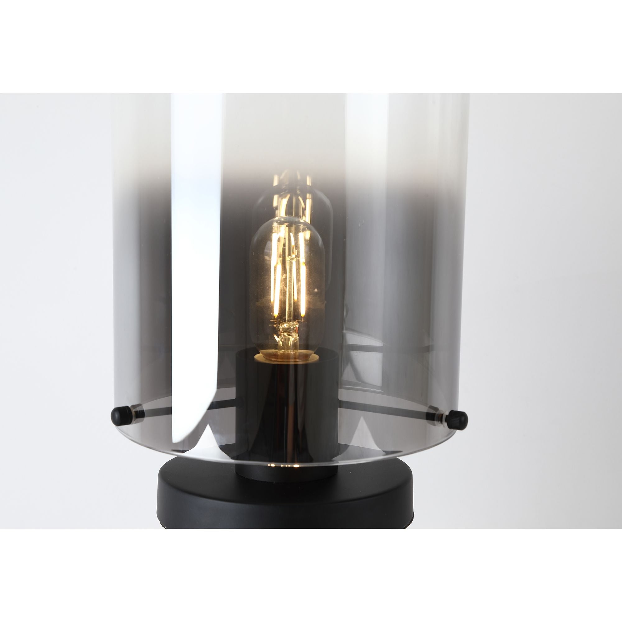 Close up of the lit bulb inside the smoked ombre glass shade on the Sweden 1 Light Table Lamp, showing the fade from charcoal to clear glass