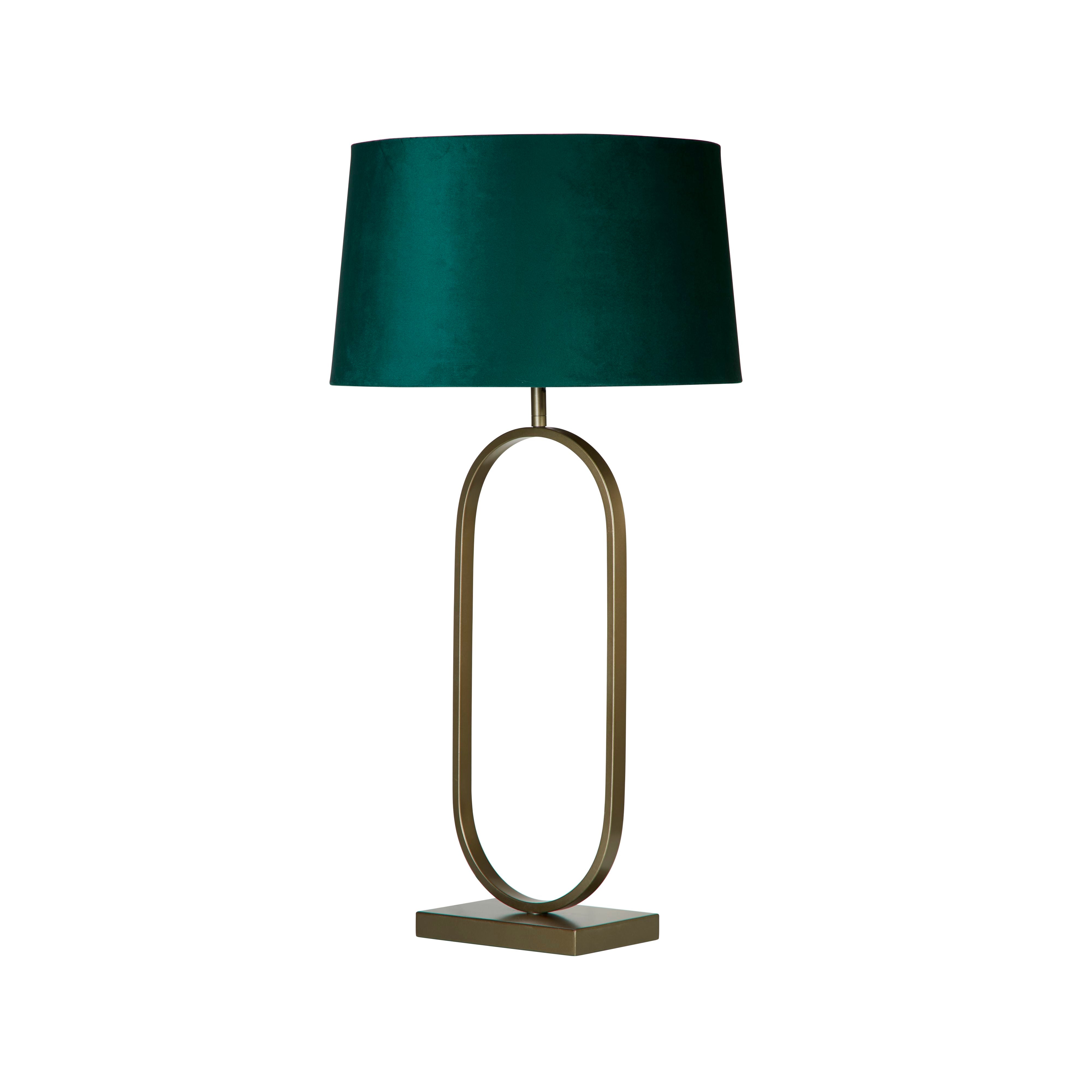Front view of the bronze oval ring based table lamp with its emerald velvet shade, on a plain white studio background