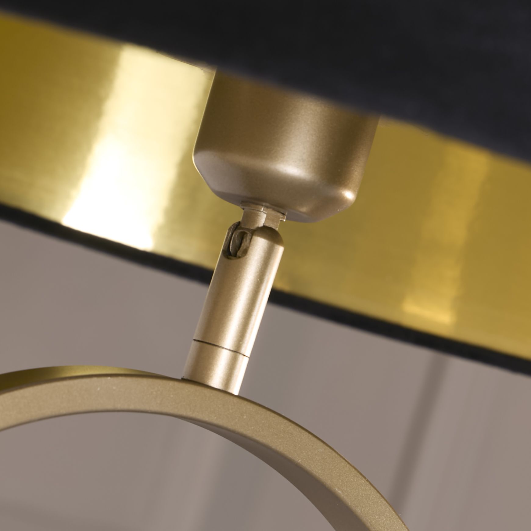 Close up of the bronze oval frame and adjustable fitting where the black velvet shade attaches, showing the gold interior shade lining