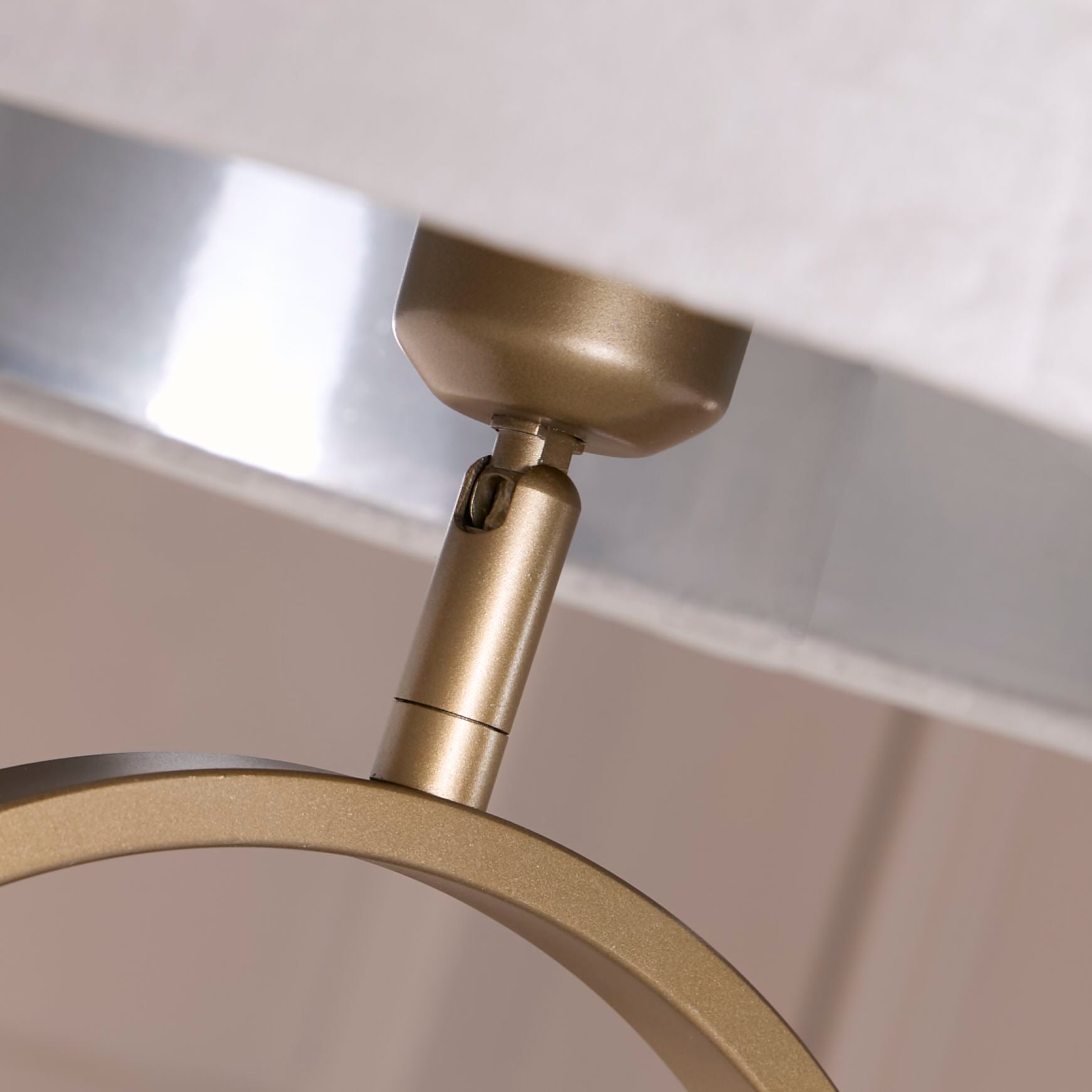 Close up of the bronze oval frame and adjustable fitting where the grey velvet shade attaches, showing the polished silver interior shade lining
