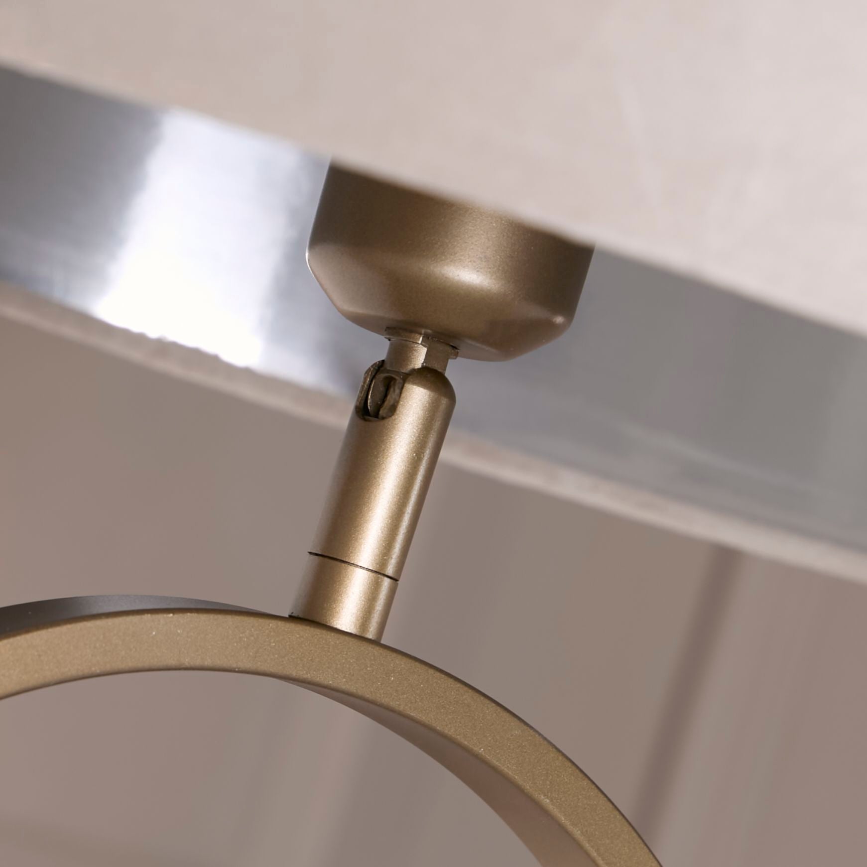 Close up of the adjustable bulb holder joint beneath the taupe velvet shade on the Modish floor lamp