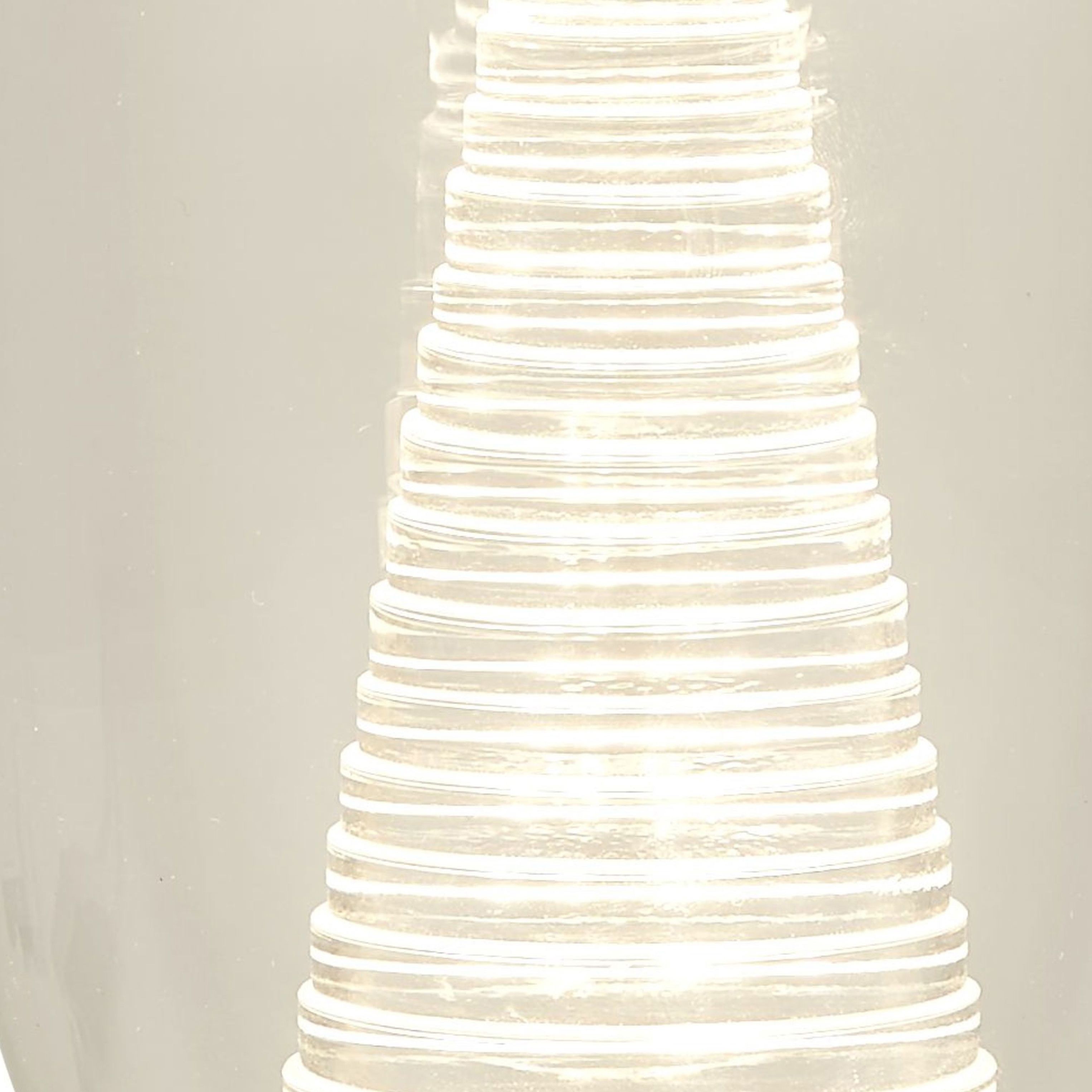 Close up of the illuminated ribbed acrylic cone inside the Cyclone table lamp's clear glass shade