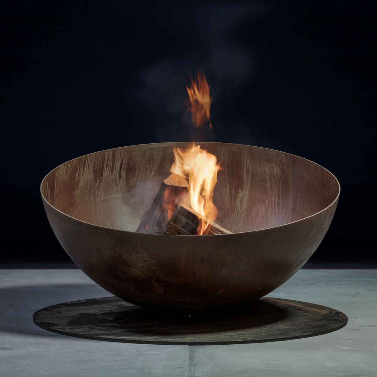 GlammFire Solace rusted Corten steel wood burning fire pit with flames rising from logs against a dark studio background