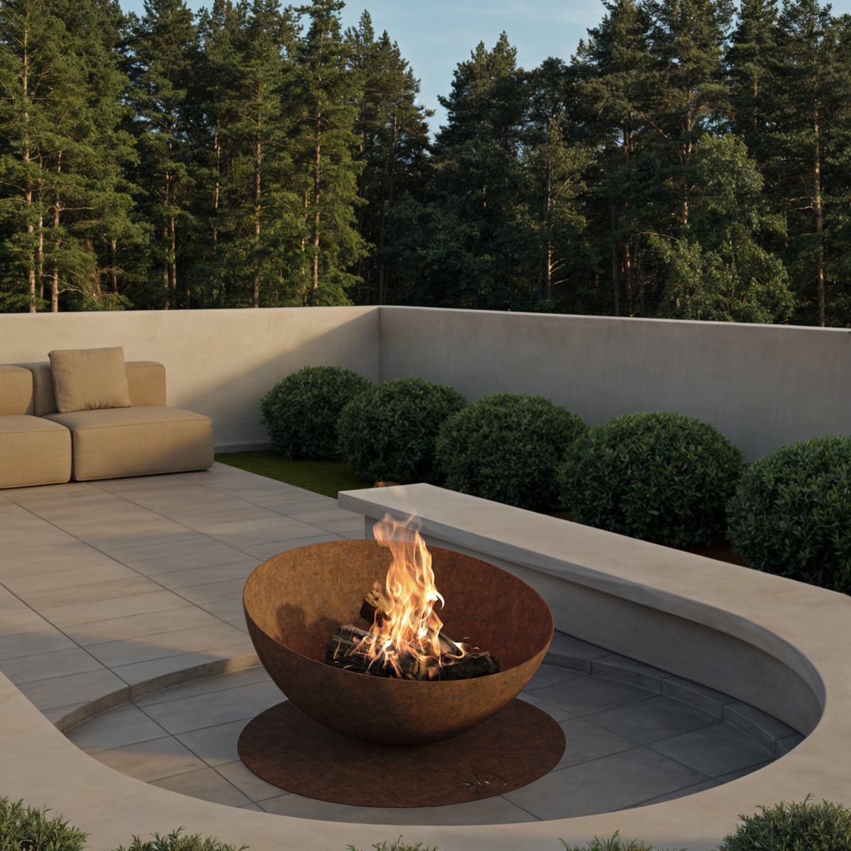 GlammFire Solace outdoor wood burning fire pit in a contemporary garden patio with outdoor sofas and green planting
