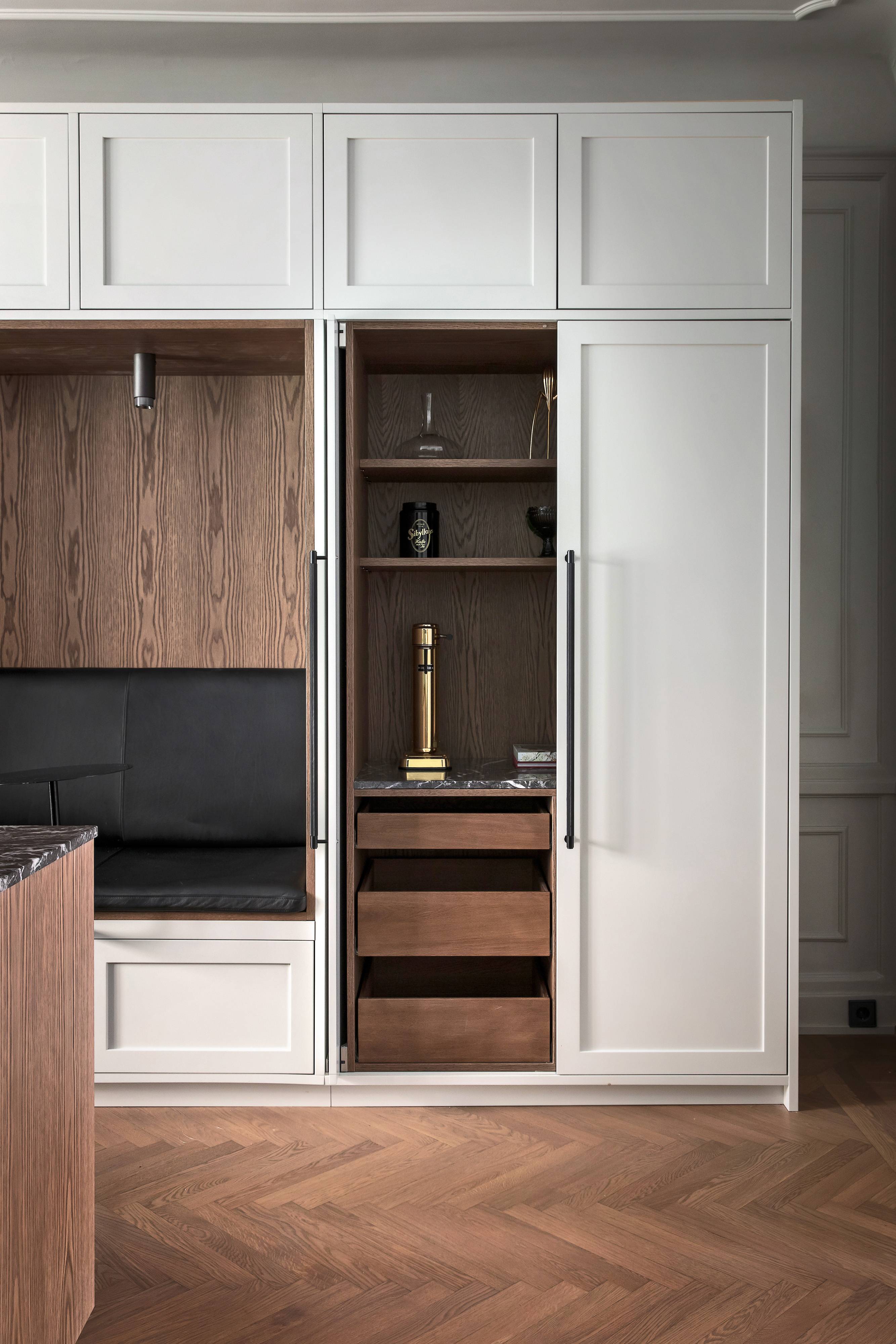 Black Cross Knurl bar pull fitted to an open cabinet door in a white kitchen pantry