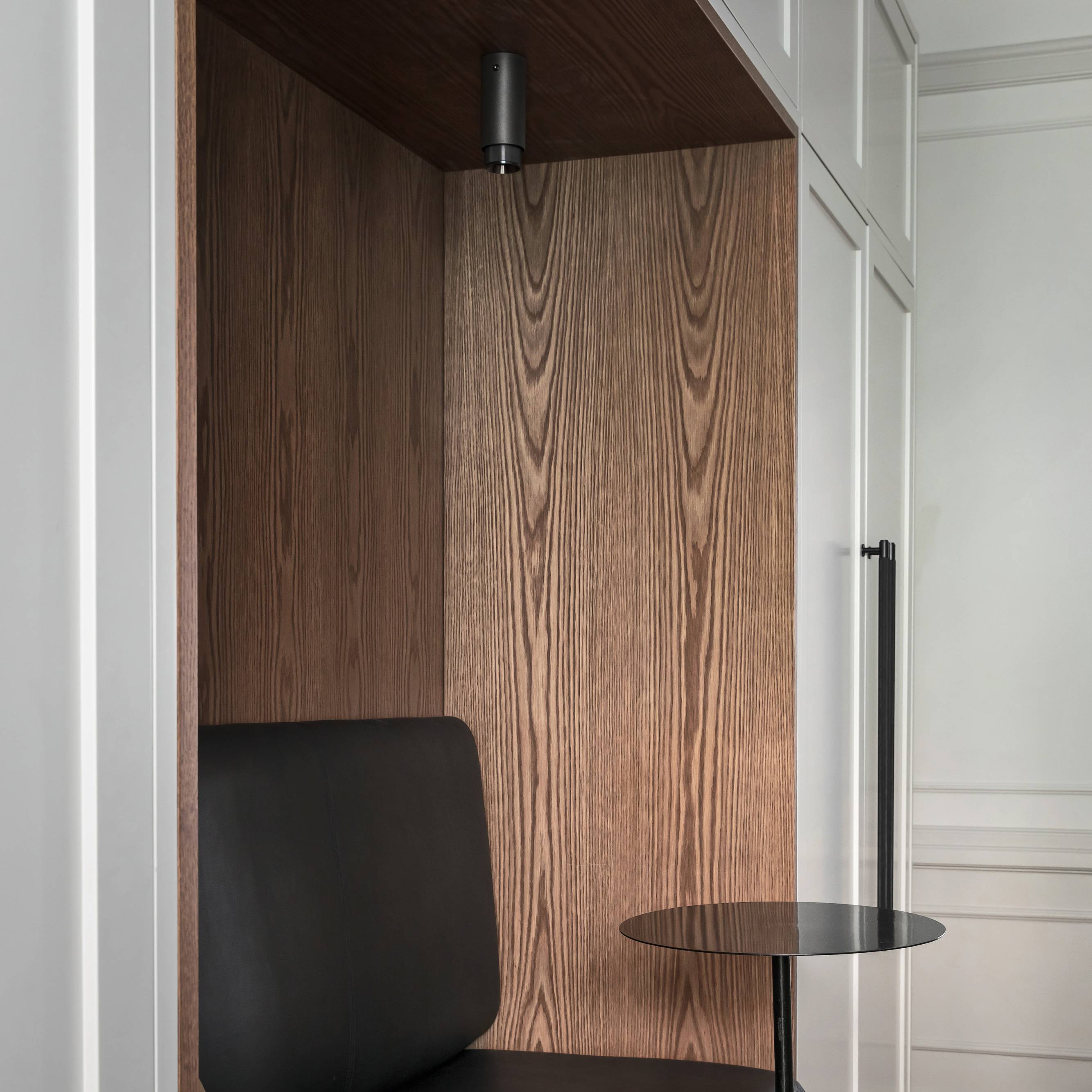 Black Cross Knurl bar pull on a wardrobe door beside a timber lined reading nook