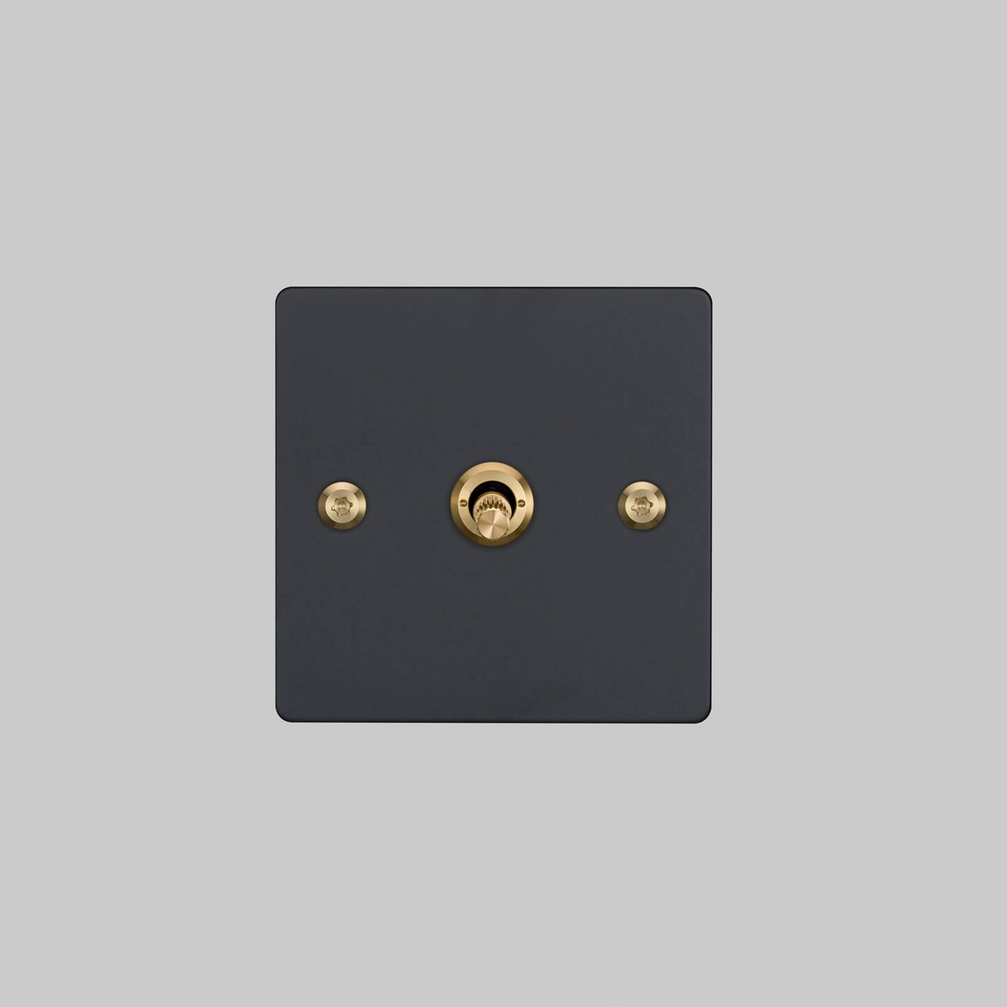 Buster + Punch 1G 2 way toggle switch, Black plate with Brass linear knurl toggle arm, elevated angle