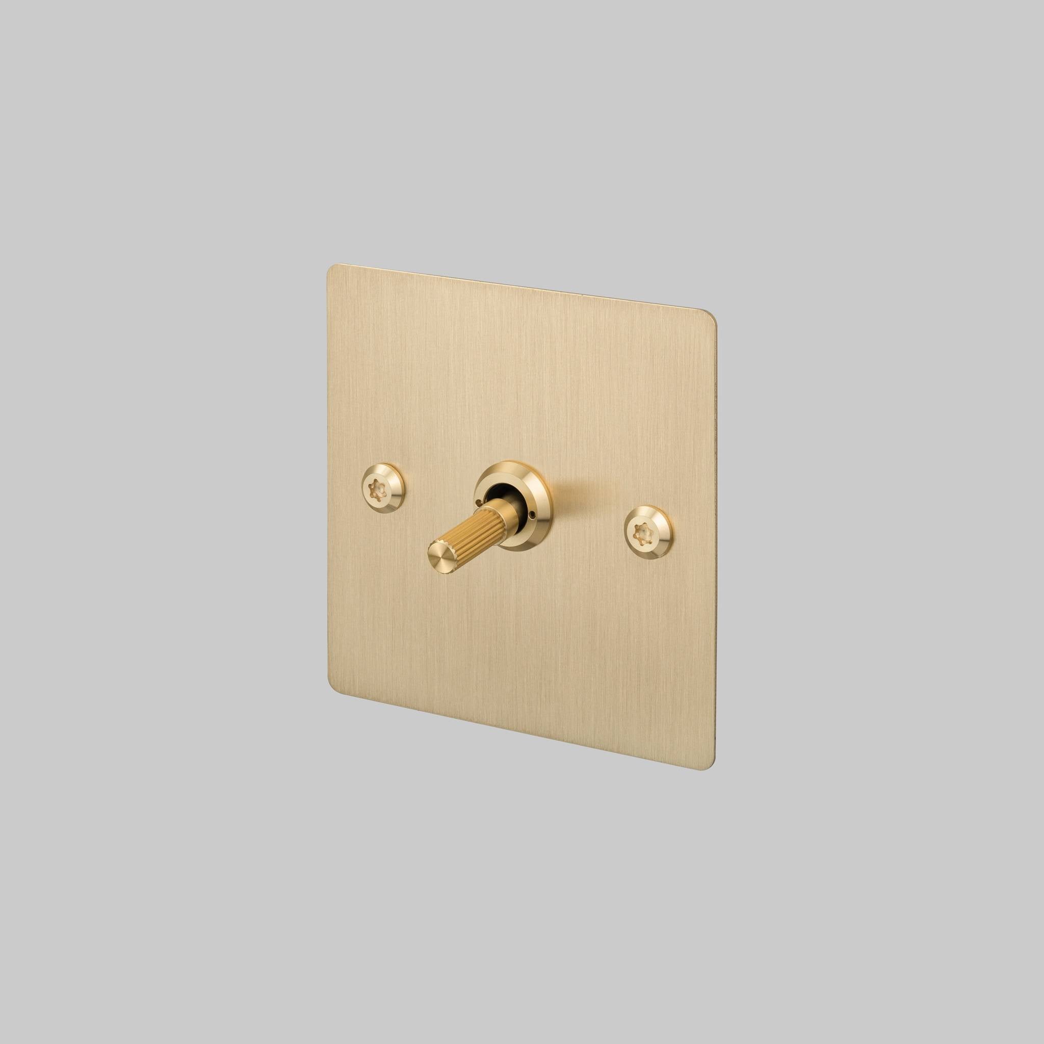 Buster + Punch 1G 2 way toggle switch, Brass plate with Brass linear knurl toggle arm, front view