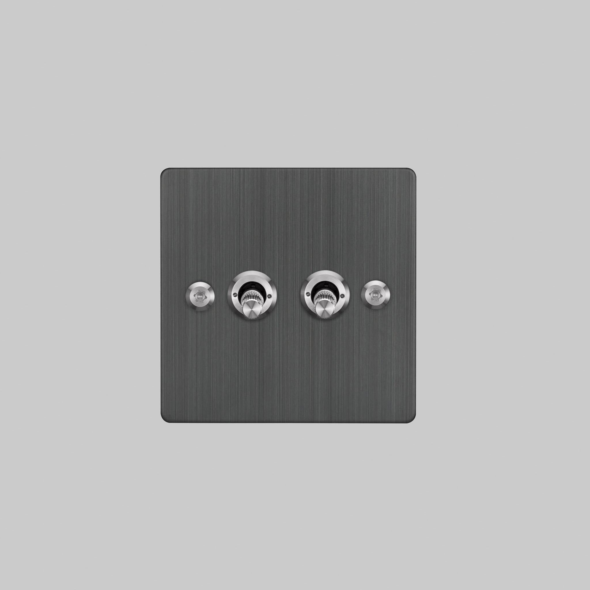 Buster + Punch 2G 2-way toggle switch, smoked bronze plate with steel linear knurl toggle arm, elevated angle view