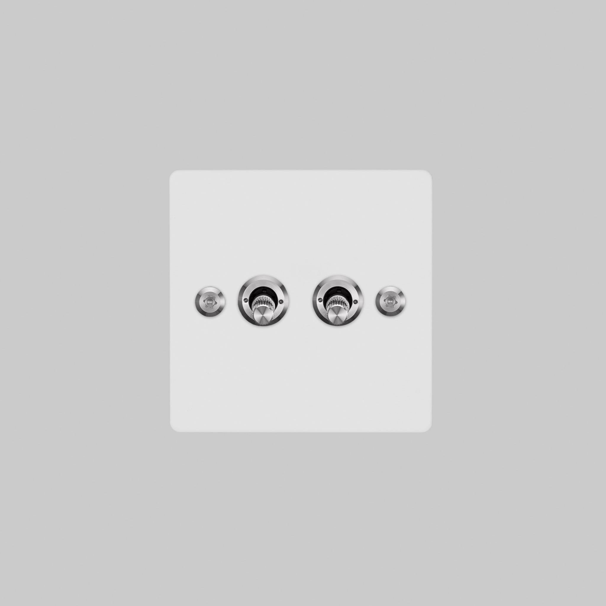 Buster + Punch 2G toggle switch, white plate with steel linear knurl toggle arms, elevated angle