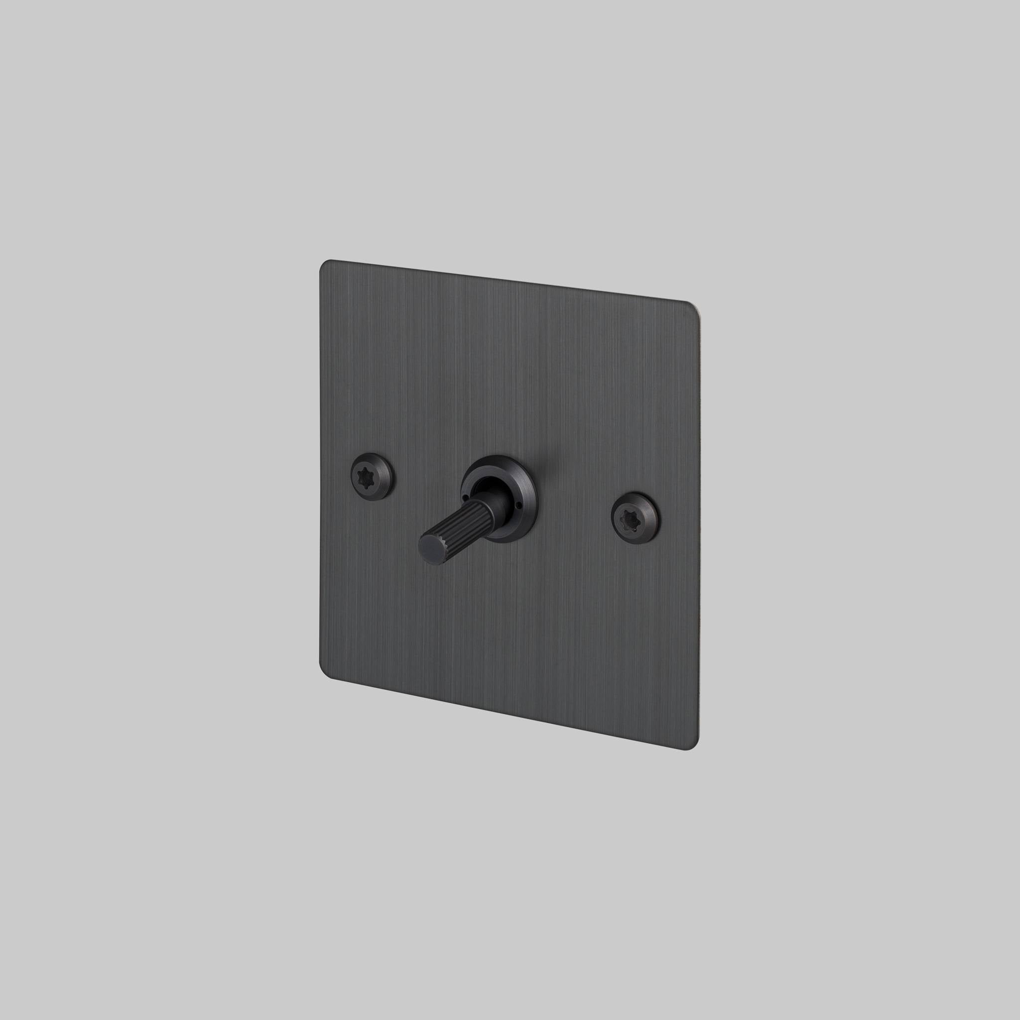 Buster + Punch 1G intermediate 3 way toggle switch, Smoked Bronze plate with Smoked Bronze linear knurl toggle arm, elevated angle view