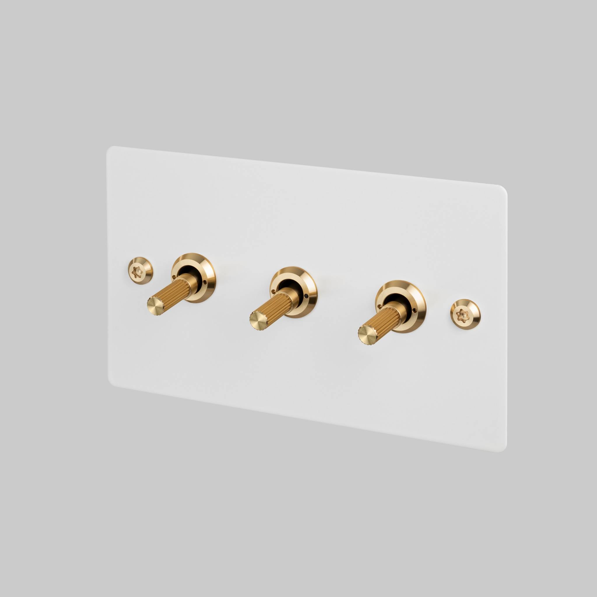 Buster + Punch 3G 2-way toggle switch, White plate with Brass linear knurl toggle arm, front view