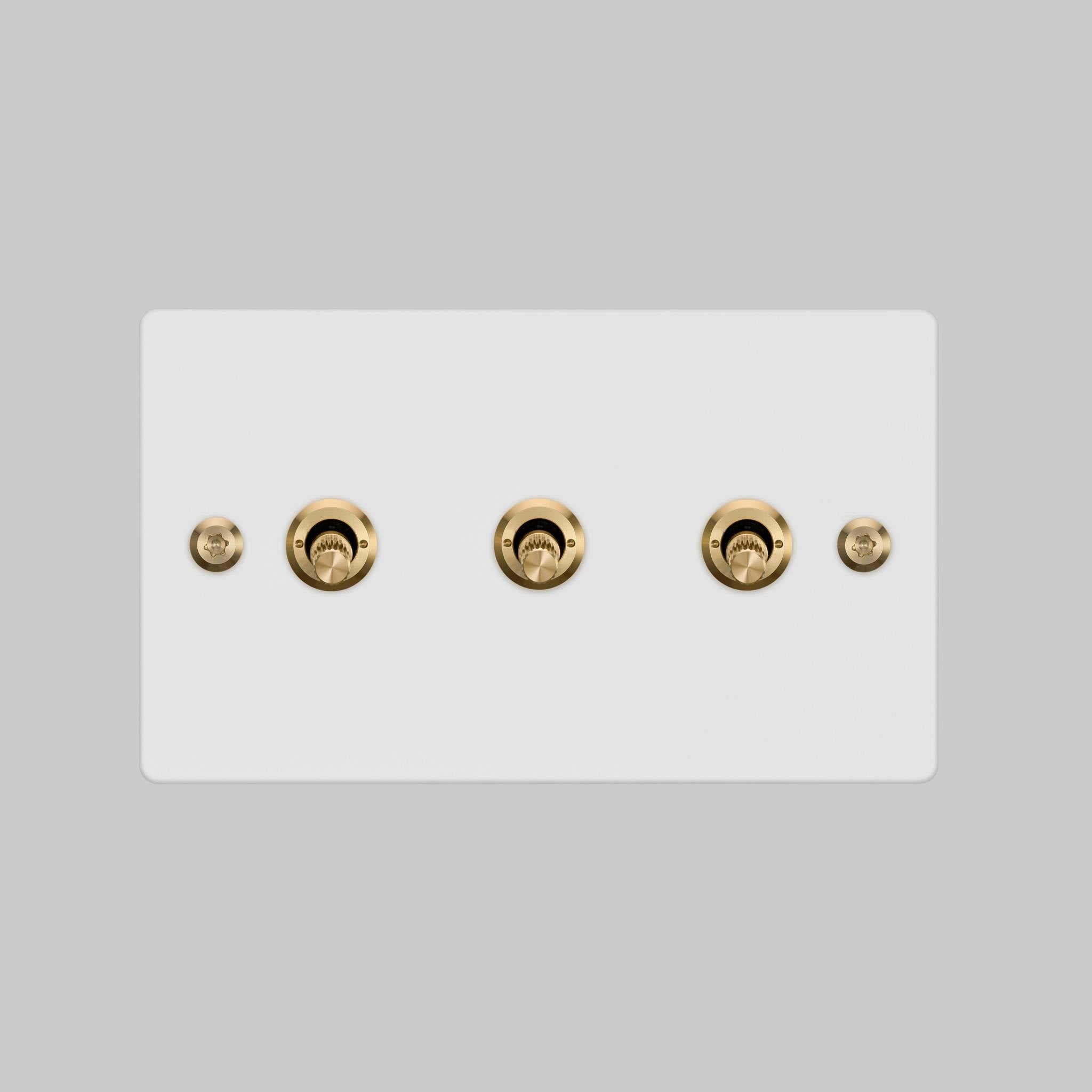 Buster + Punch 3G 2-way toggle switch, White plate with Brass linear knurl toggle arm, elevated angle